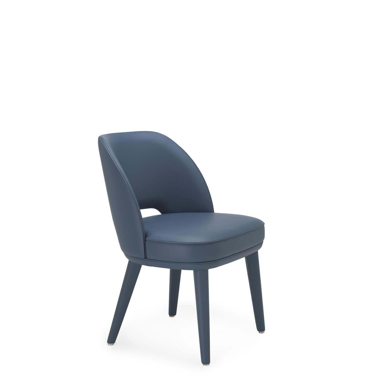 Penelope is a padded chair that features soft volumes and welcoming shapes. The fluid lines of the backrest and the lightness of the legs are enhanced by the covering in Tosca leather (cat. S), proposed in an elegant blue colour. A fine selection of