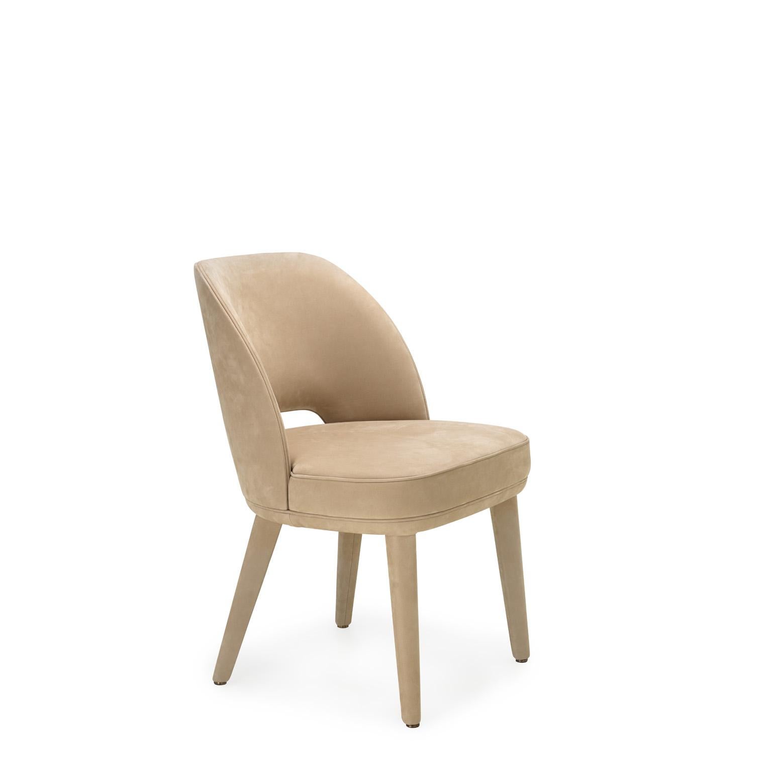 Penelope is a padded chair that features soft volumes and welcoming shapes. The fluid lines of the backrest and the lightness of the legs are enhanced by the covering in Carmen leather (cat. L), proposed in an elegant Conchiglia colour. A fine
