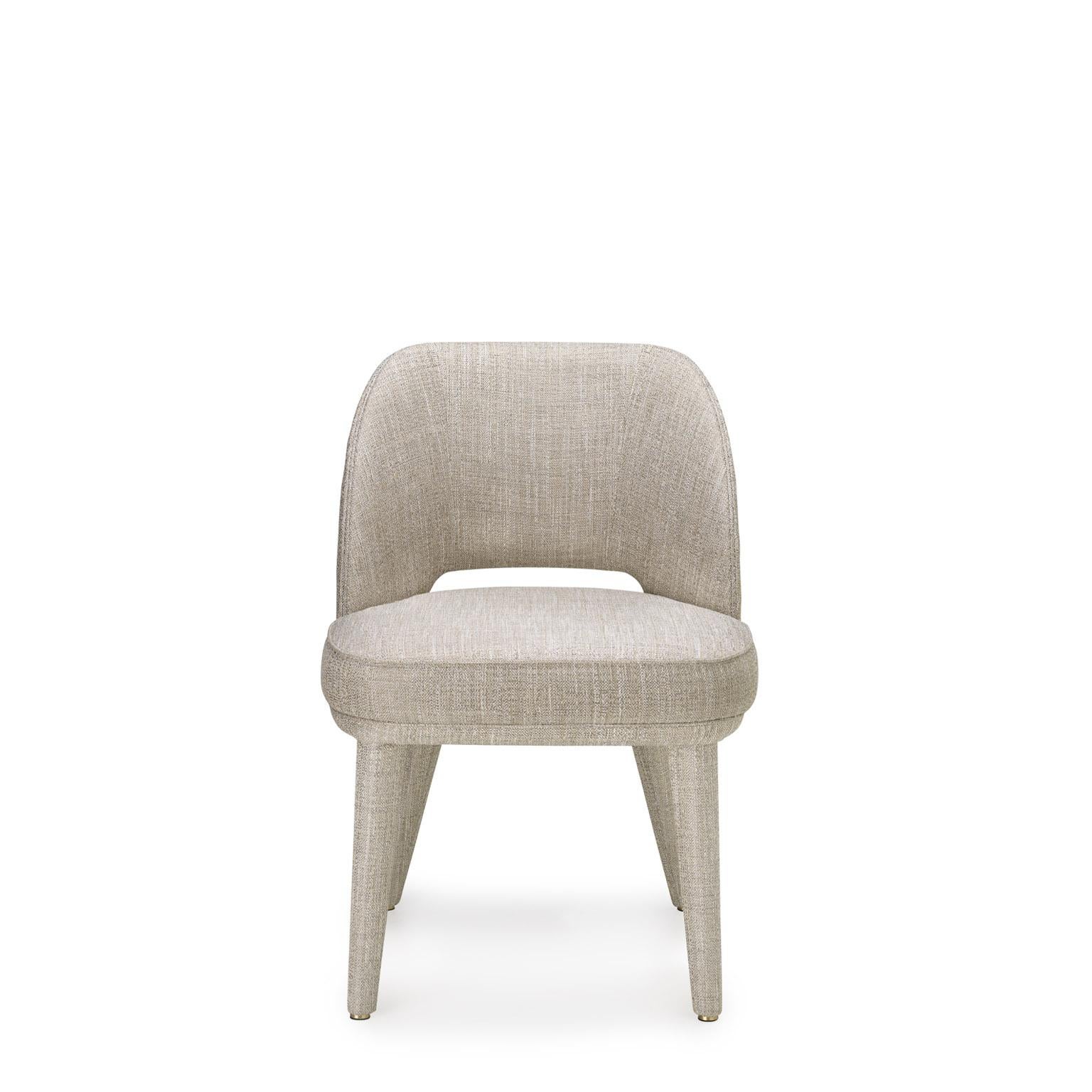 Penelope is a padded chair that features soft volumes and welcoming shapes. The fluid lines of the backrest and the lightness of the legs are enhanced by the covering in a textured Sparks fabric (cat. B), proposed in a neutral Perla colour. A fine