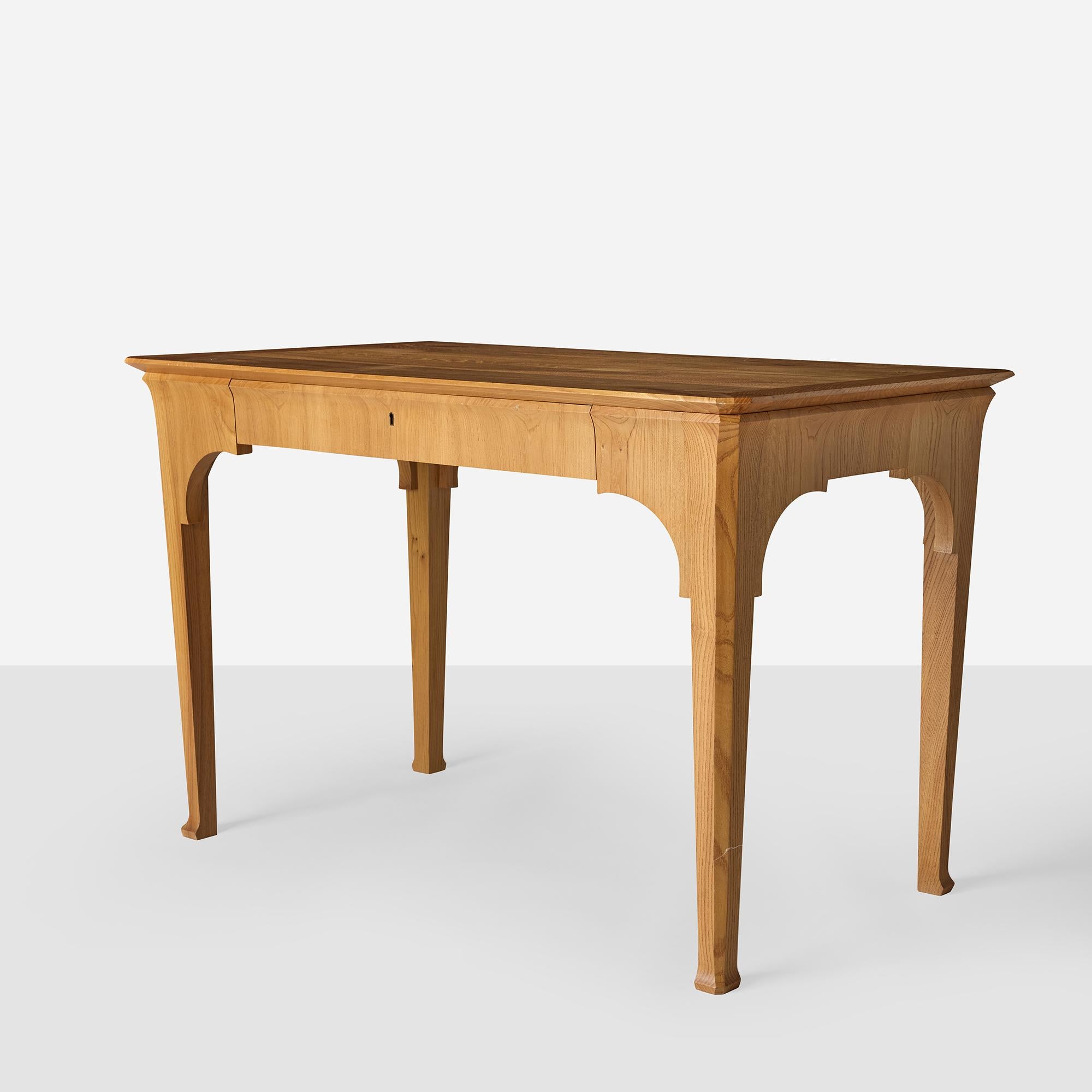 A free-standing honey-colored elm writing desk with single lockable front drawer, arched apron, and tapered legs. Modern construction in the style of Peter Vilhelm Jensen-Klint, circa 1904. Made exclusively for Almond 
Co., United States, 2013.
