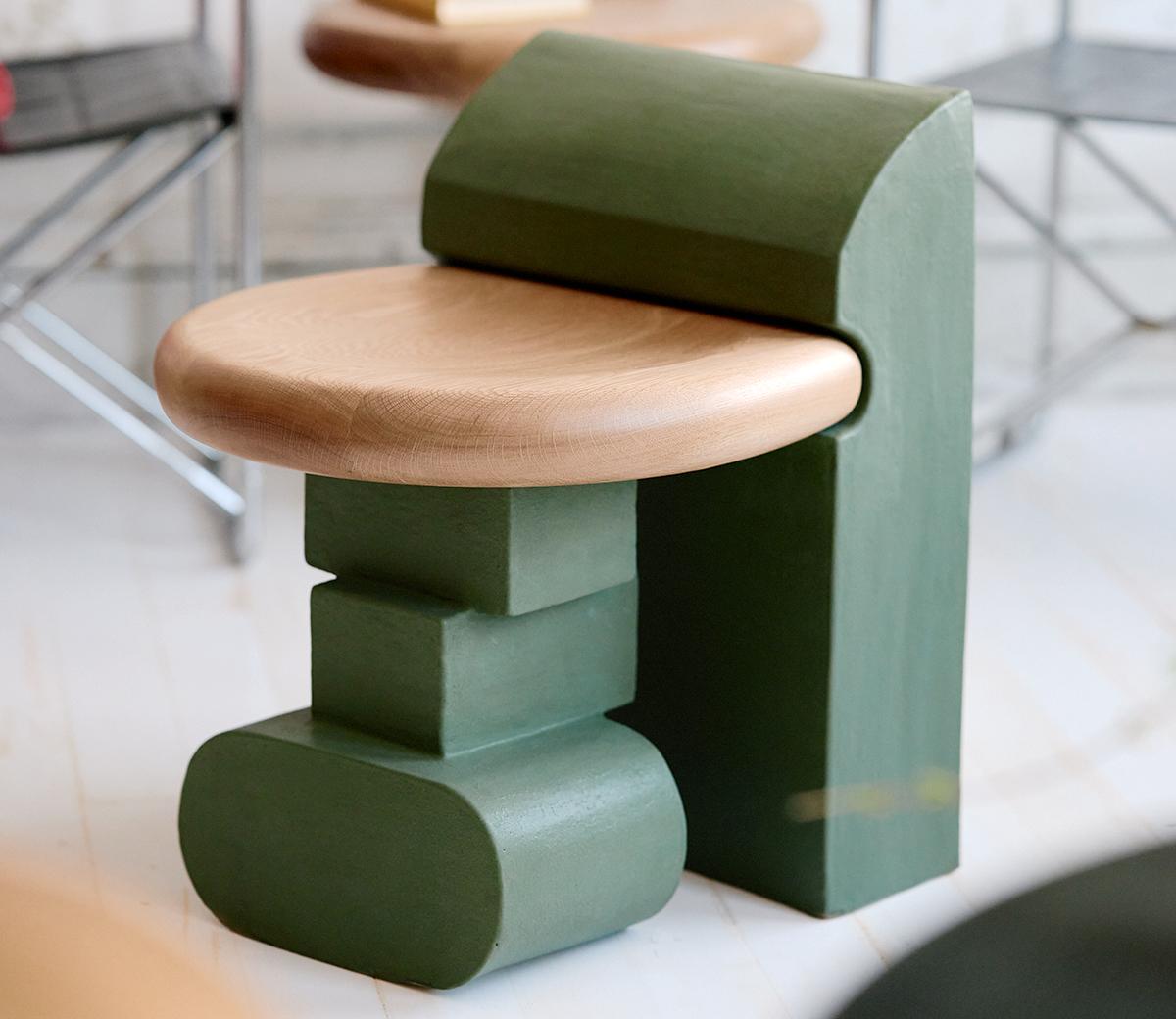 Dieser skulpturale Hocker besteht aus drei einzelnen Elementen, die sich ineinander schmiegen. Die handgefertigte Lehne und die Beine aus Ton stützen die Sitzfläche aus massiver Eiche und machen ihn zu einer perfekten, modularen Sitzgelegenheit für