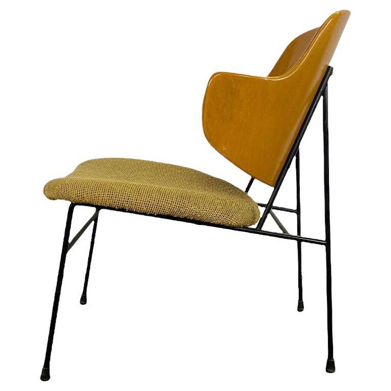 Classic Penguin chair designed by Ib Kofod Larsen and produced by Selig. Gorgeous molded birch upper shell provides contoured support with original upholstered seat atop black iron frame. Elegant minimal silhouette with bold styling make this a