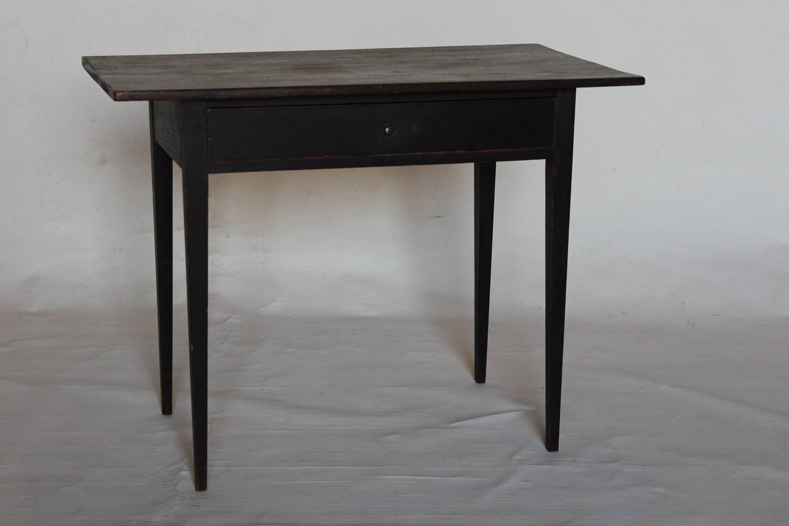 A charming walnut and pine single-drawer table with an early, perhaps original, black-painted finish. This table was likely made in Pennsylvania, circa 1820. Its size and proportions make it an ideal side table or small desk.

Measures: Ht 27 ½’,