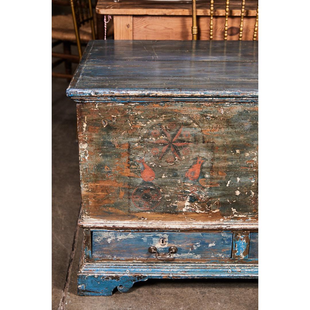 This piece is a Classic example of a Pennsylvania blanket box or dowry chest with painted elements and carved feet. It has three exterior drawers and an interior till or safe. From the wear and techniques used, this piece could be from as early as