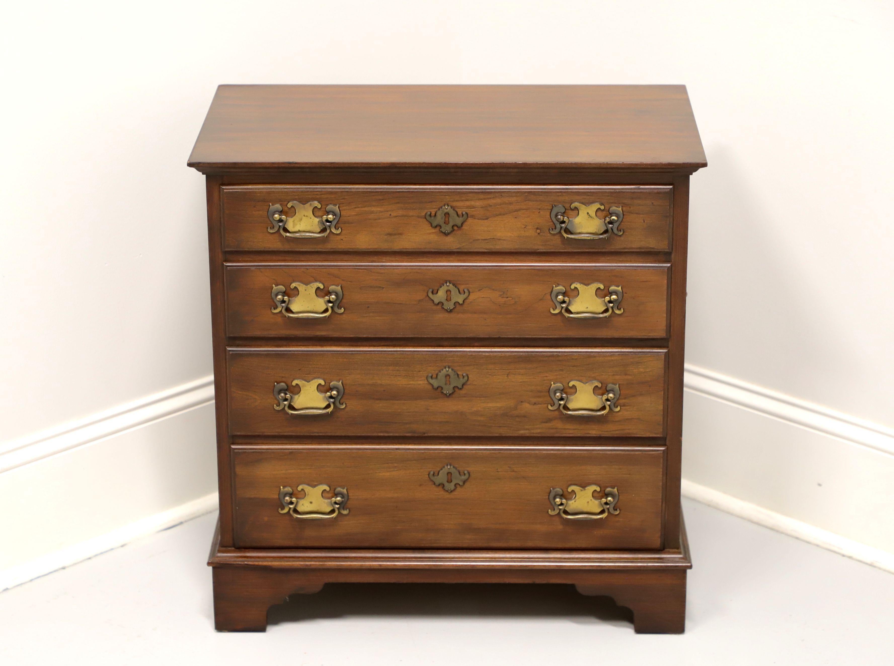 A Chippendale style chairside chest by Pennsylvania House. Solid cherry wood, brass hardware, brass side handles, fully finished back, and bracket feet. Features four drawers with faux keyhole escutcheons. Made in the USA, in the late 20th