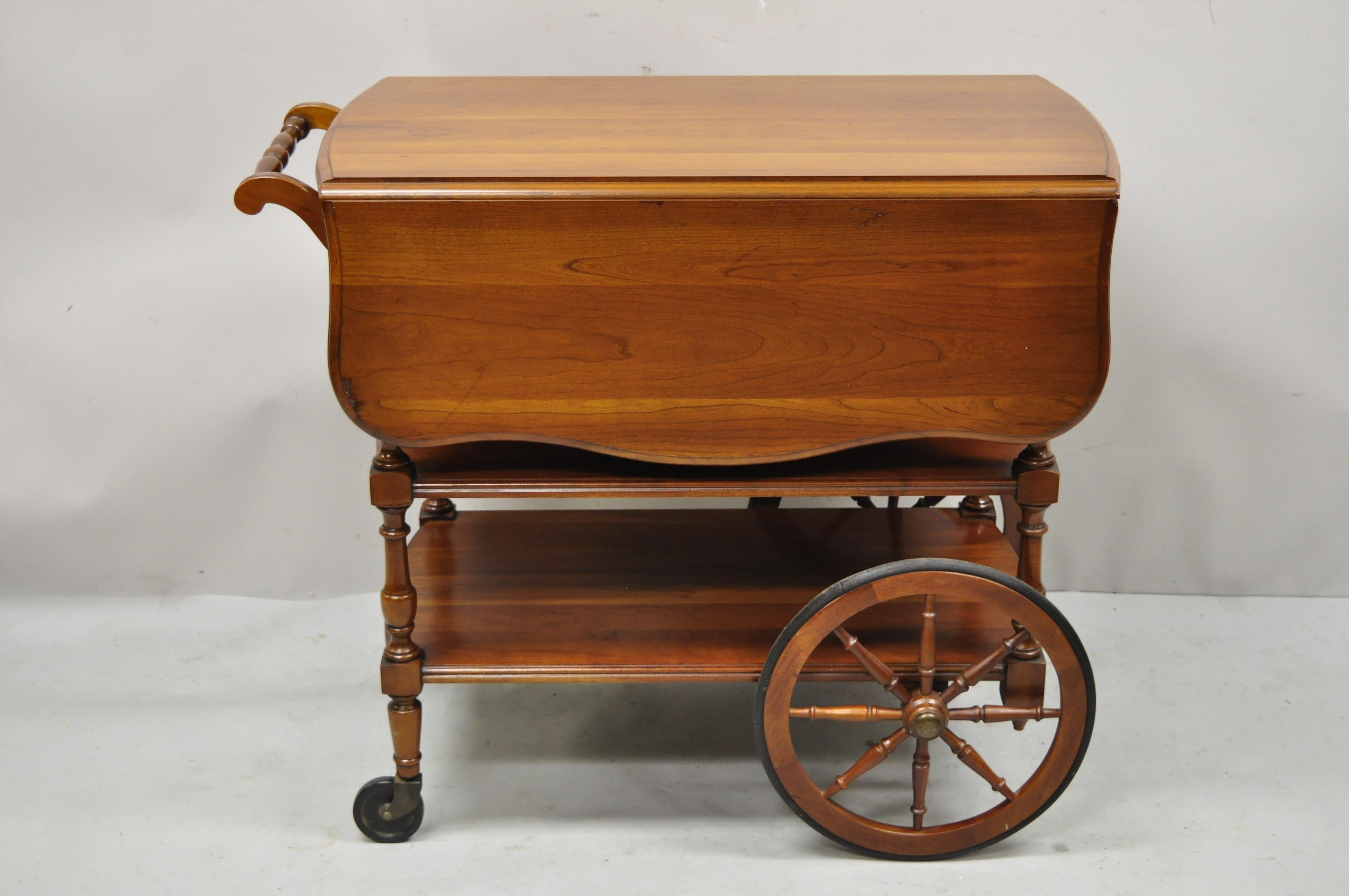 Vintage Pennsylvania House cherry wood drop leaf rolling tea cart server with drawer. Item features drop leaf sides, 2 lower shelves, rolling wheels, solid cherry wood construction, beautiful wood grain, original label, 1 drawer, very nice vintage