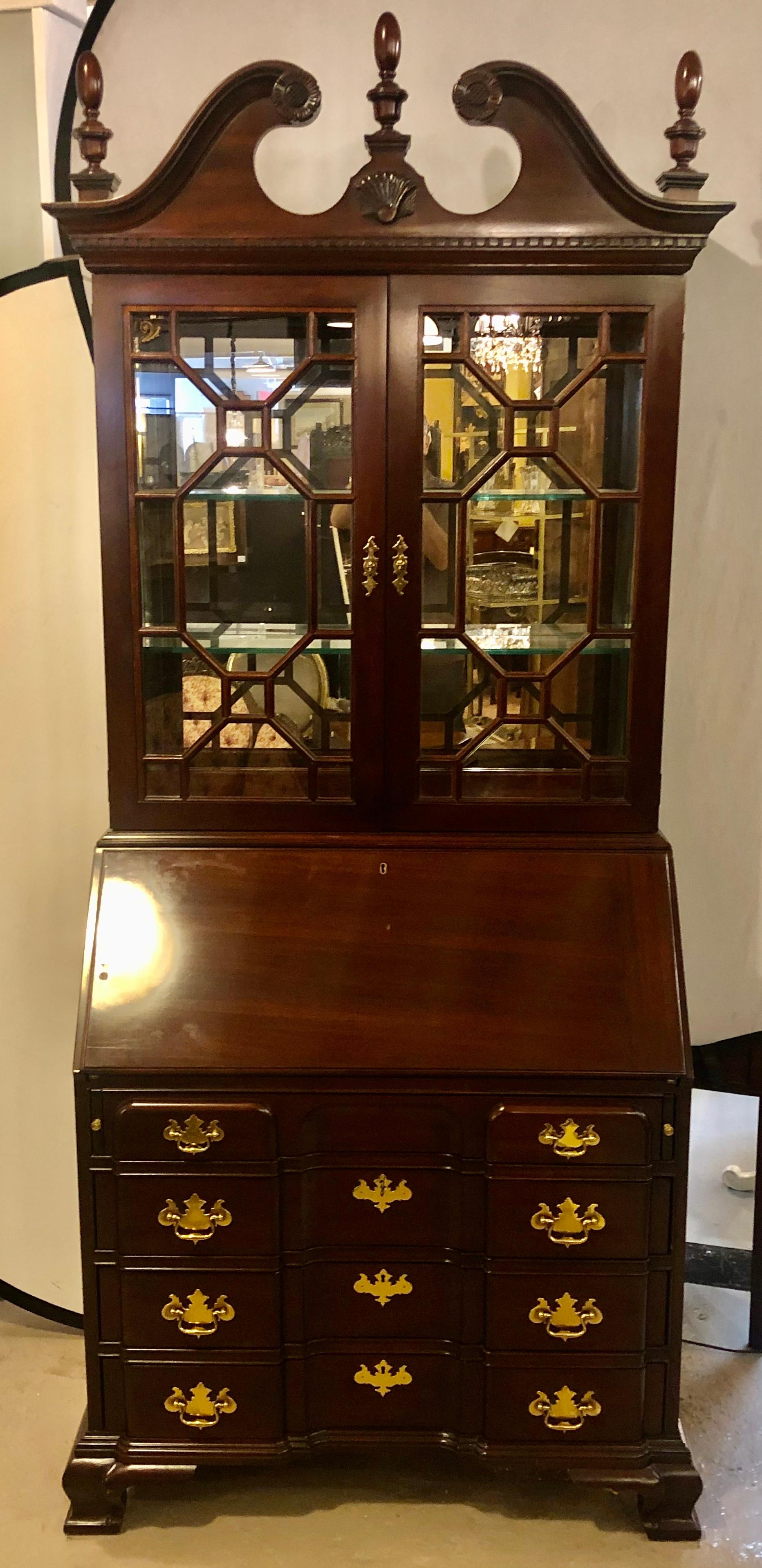 Pennsylvania House secretary desk / bookcase. This fine mahogany block front two-piece Chippendale style secretary bookcase cabinet has a lighted all mirrored with polished edges interior. The drop down slant front having a writing surface with