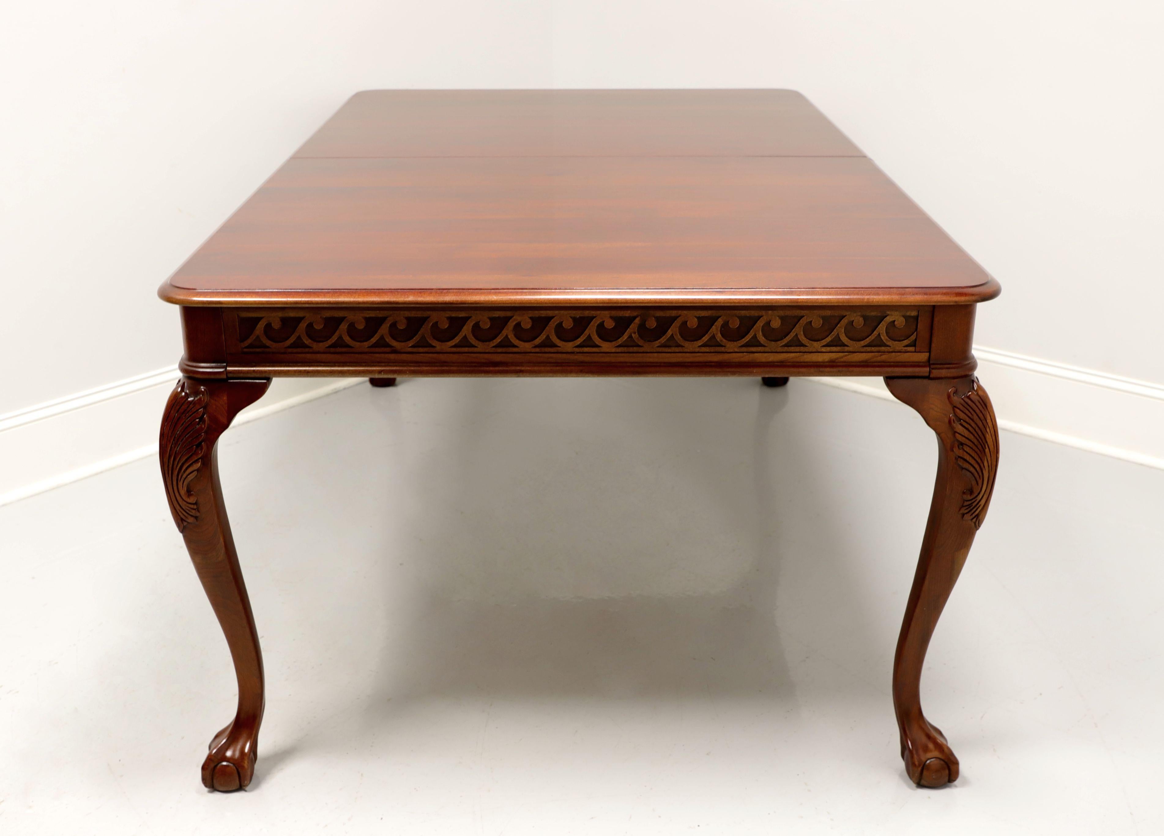 A Chippendale style rectangular dining table by Pennsylvania House. Solid cherry with carved apron, carved acanthus leaf to knees and ball in claw feet. Metal expansion sliders. Includes two extension leaves. Made in the USA, in the early 21st