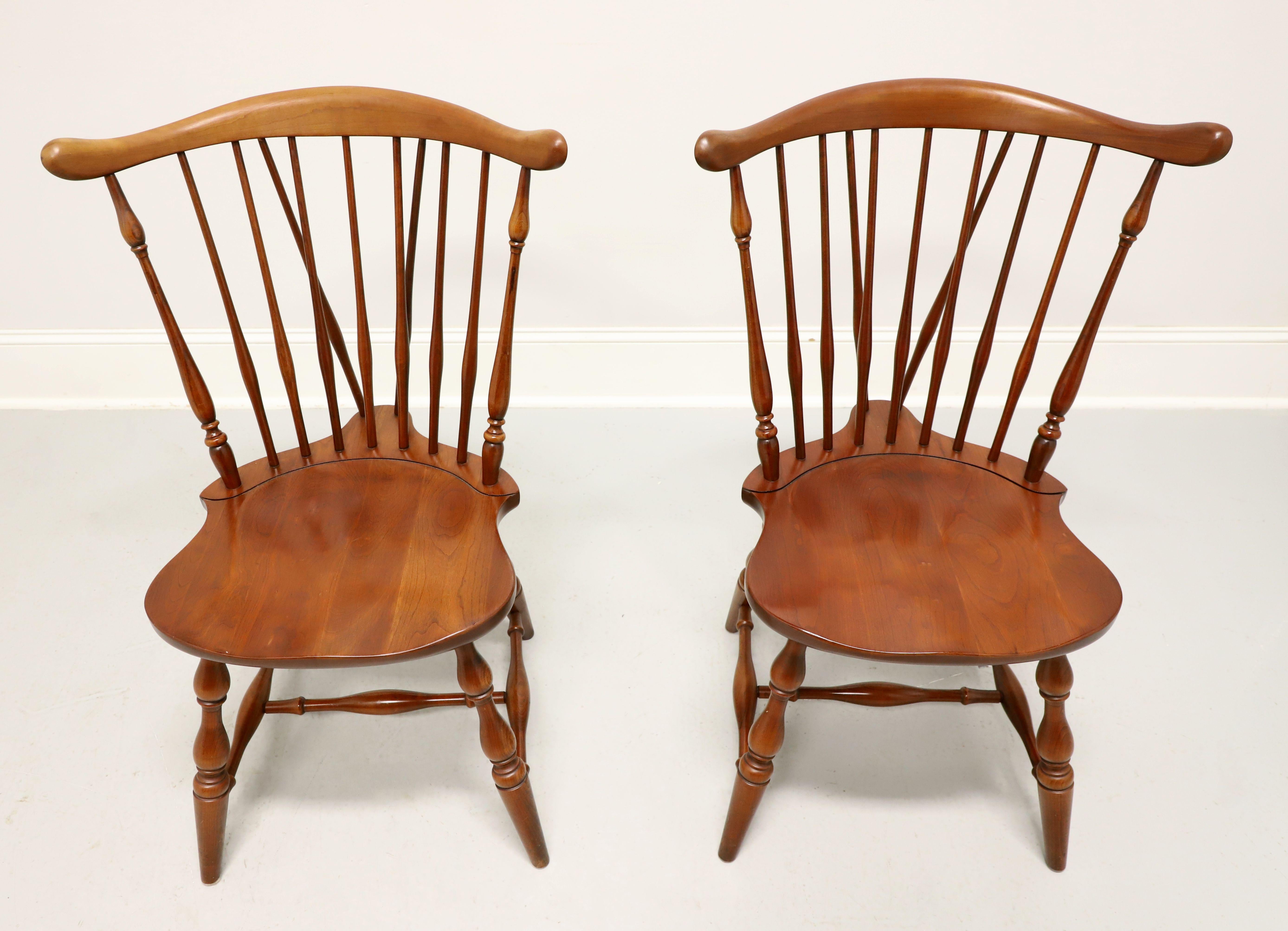 A pair of Windsor style dining side chairs by Pennsylvania House. Solid cherry wood, fiddleback with turned side spindles, saddle shape seat, tail-supports with spindles, turned legs and stretchers. Made in the USA, circa 1962.

Measures:  Overall: