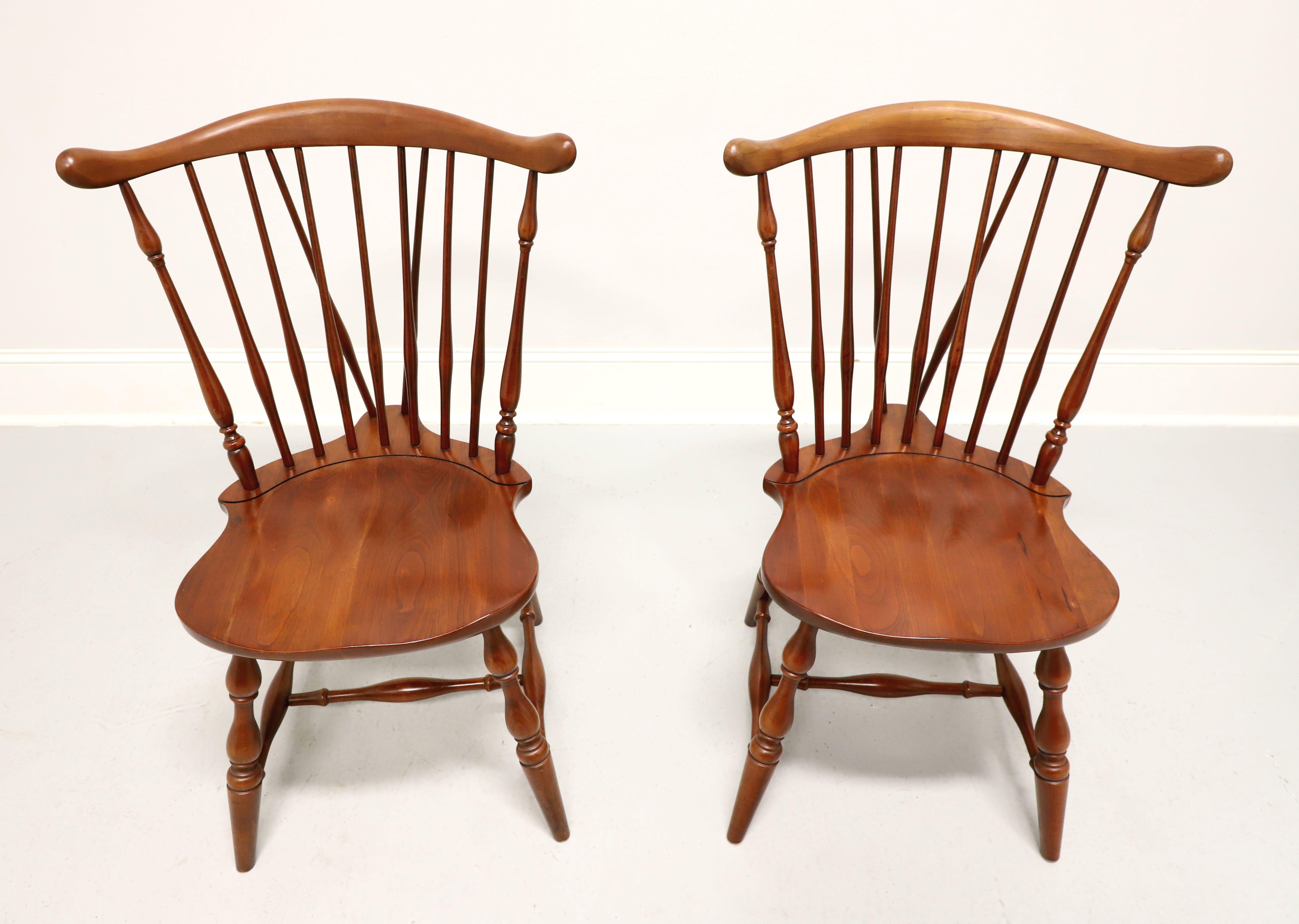 A pair of Windsor style dining side chairs by Pennsylvania House. Solid cherry wood, fiddleback with turned side spindles, saddle shape seat, tail-supports with spindles, turned legs and stretchers. Made in the USA, circa 1962.

Measures:  Overall: