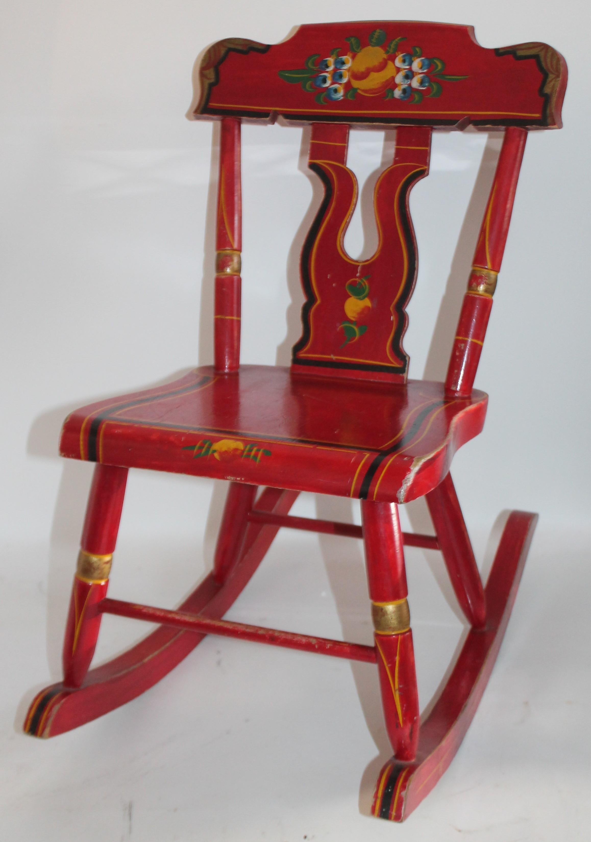 This early 20th century original red painted and decorated handmade children's rocking chair is in fine condition. It was made in Lancaster County, Pennsylvania.