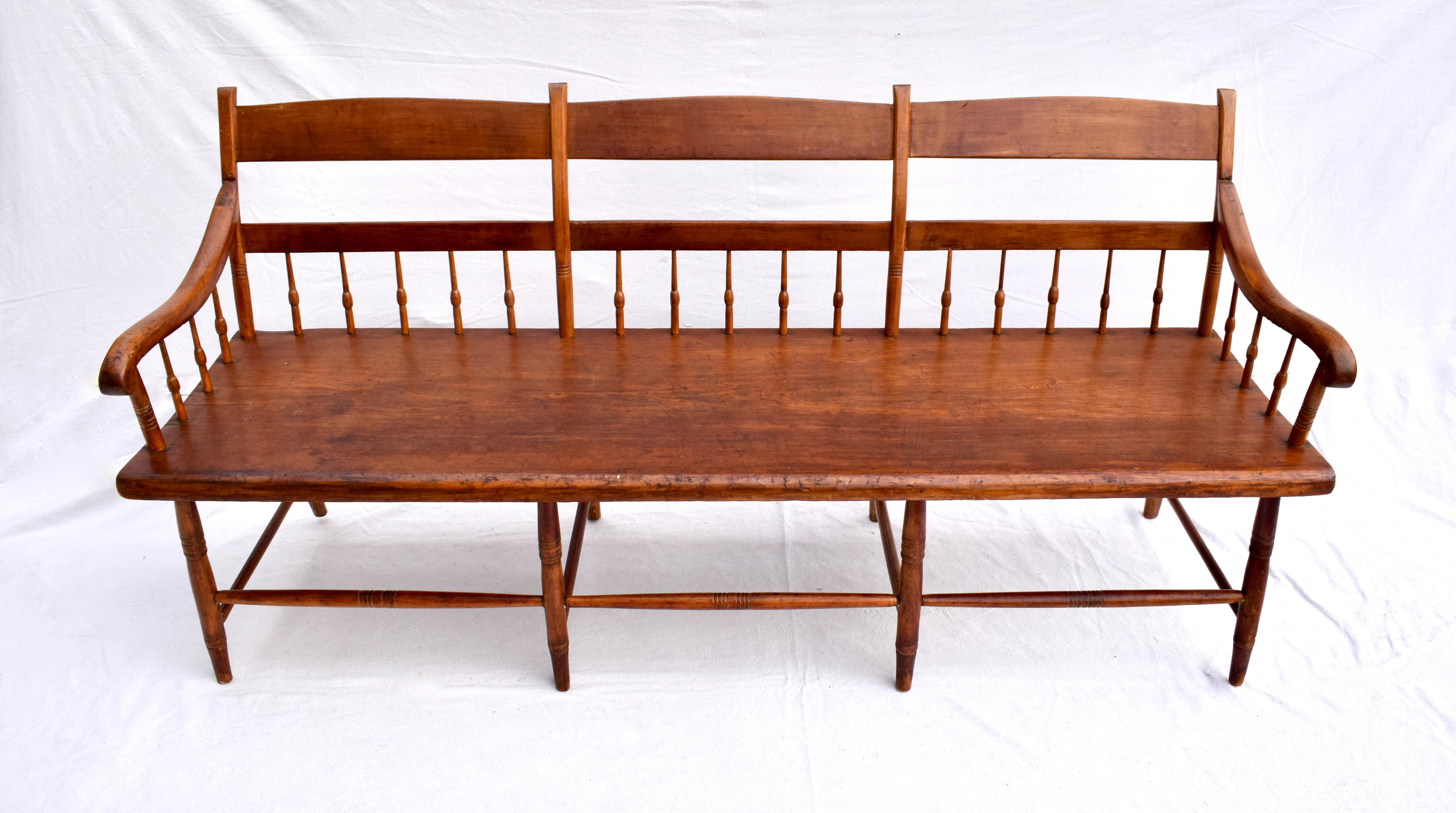 An American 19th century Pennsylvania deep single board plank-seat bench in the half-spindle-back style with mortis & tenon joinery. Beautifully maintained original finish & patina fully hand detailed enhanced with new upholstered custom notched
