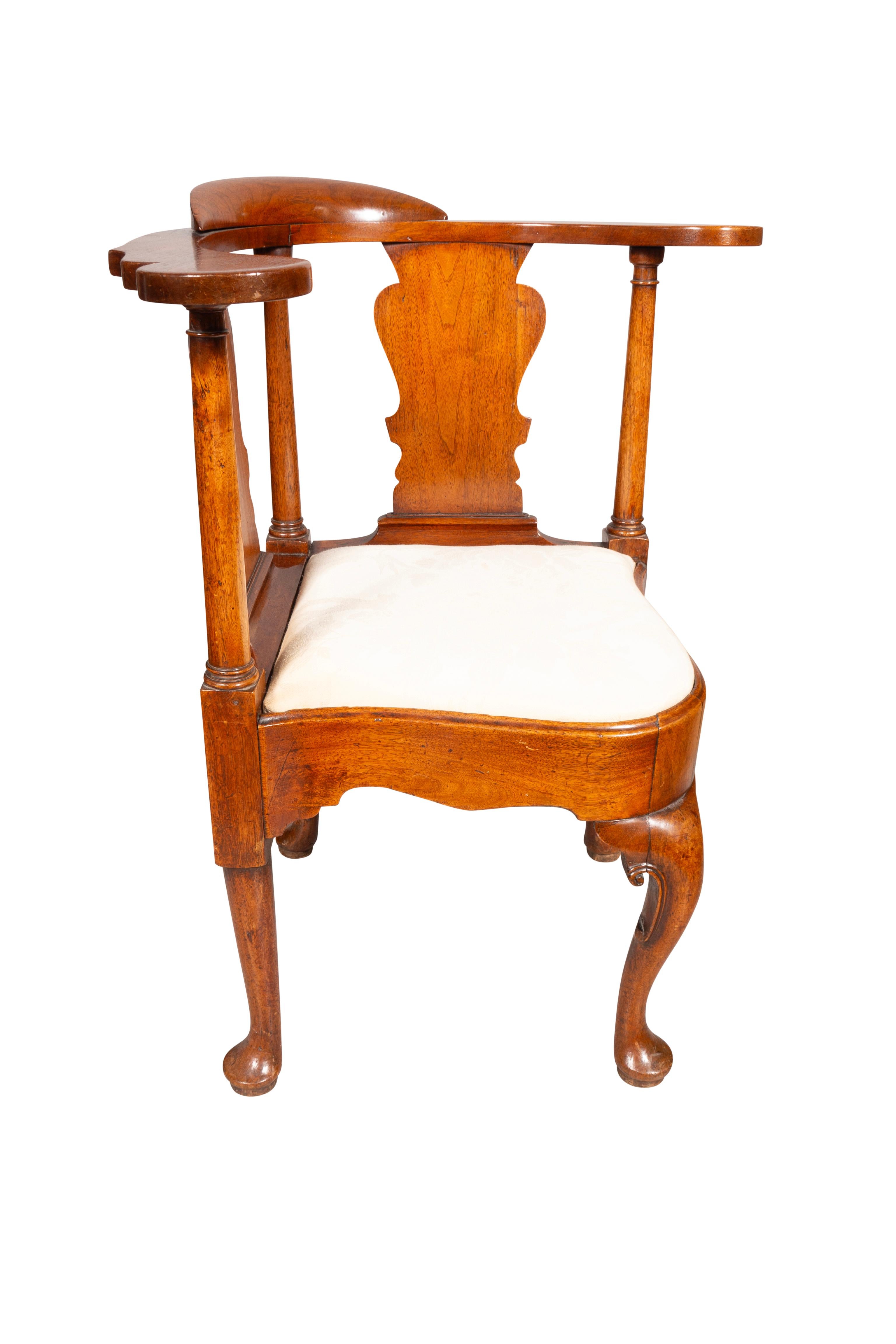 Classic chair with curved back and shaped arms, drop seat and variform splats, with cabriole legs with carved C-scrolls and ending on pad feet.