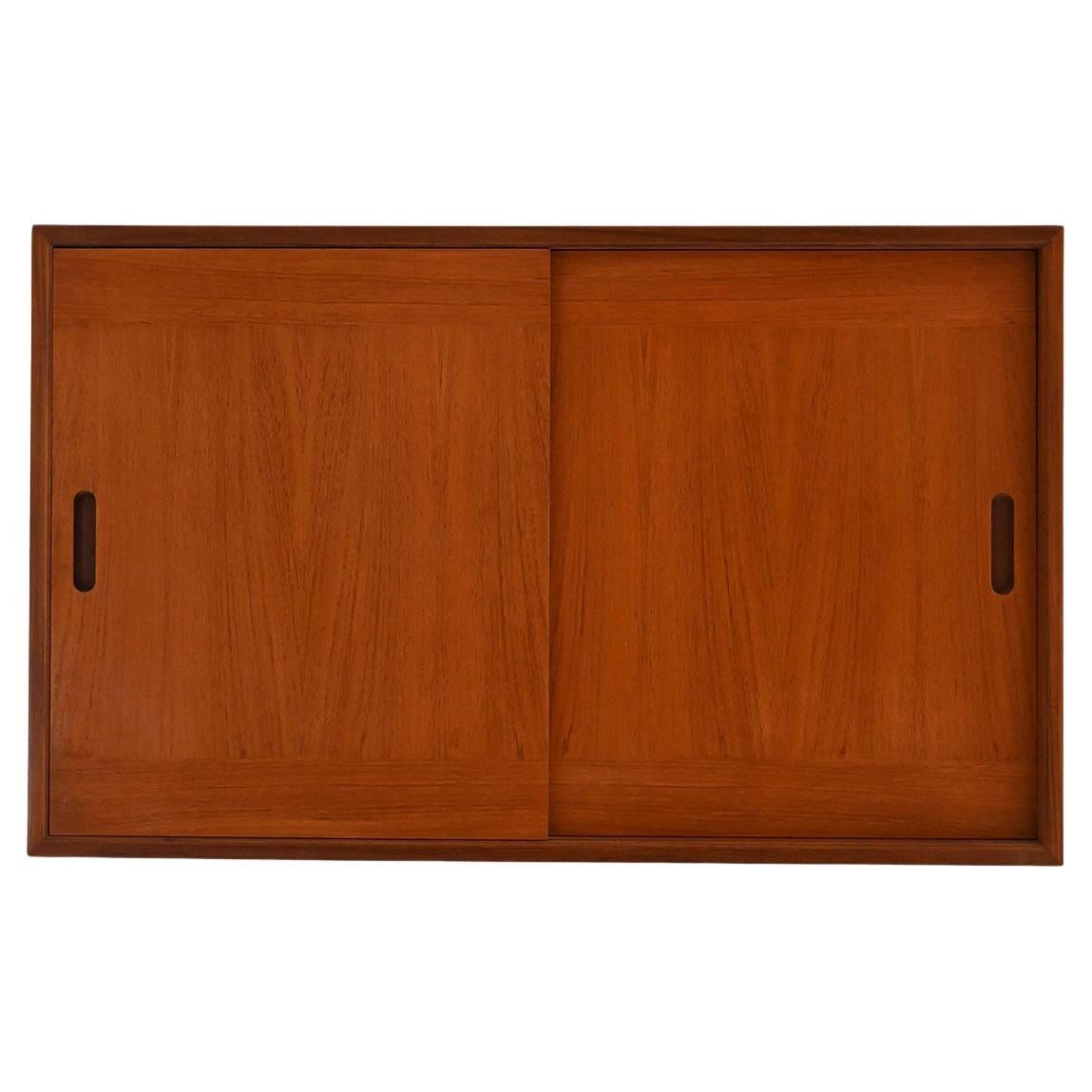 Armario de pared escandinavo de teca de los años 60 con puertas correderas y ganchos interiores en venta