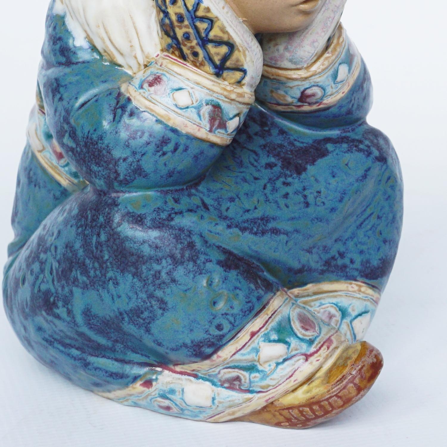 'Pensive Inuit Girl' pottery figure sculpted by Francisco Catalá for Lladró. First issued in 1985. Depicting a young Inuit girl sitting with her mittens pressed to her face. Excellent fine hand painted detail. Numbered 2158.

Dimensions: H 16.5cm W