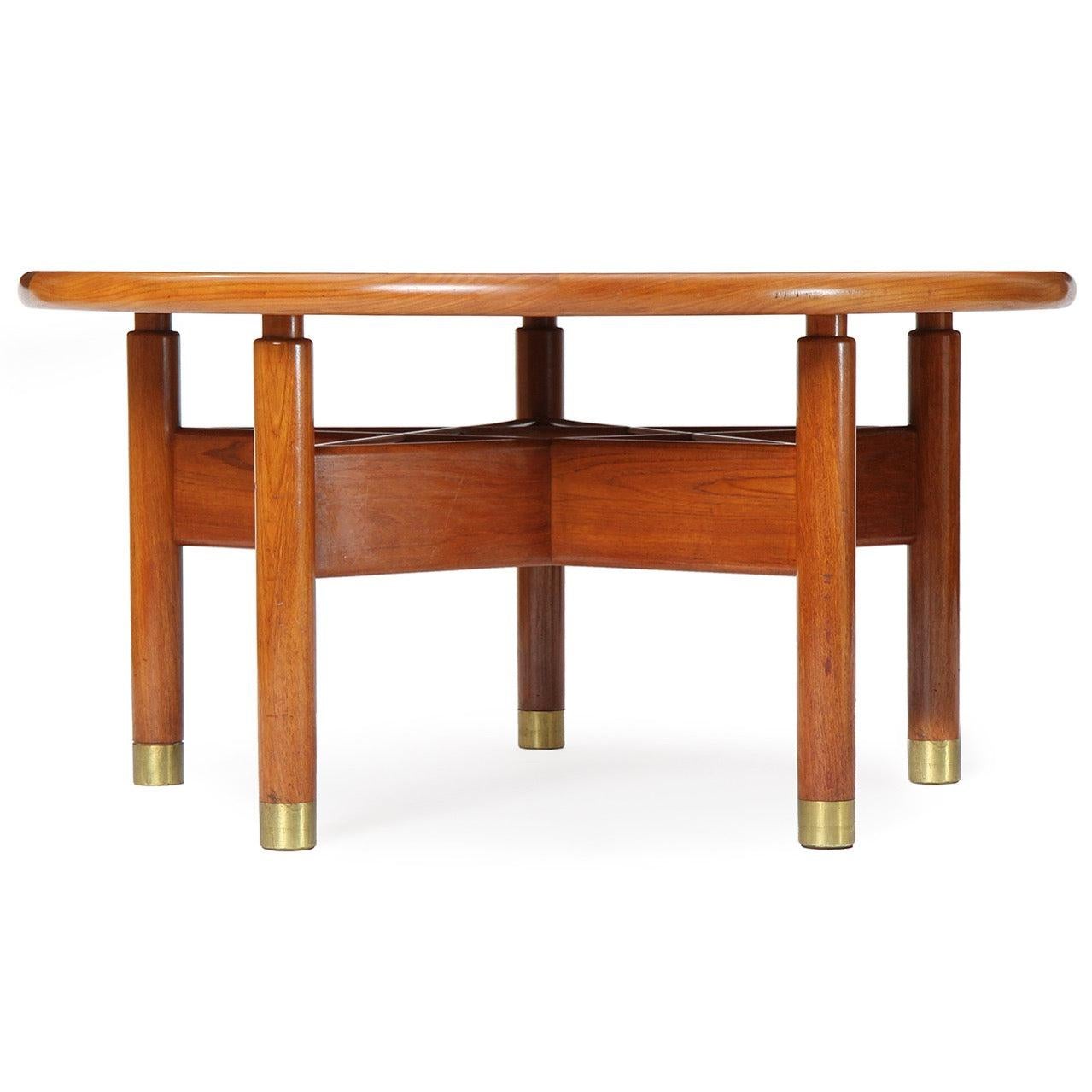 A privately commissioned Burmese teak dining or center table of beautiful scale and proportion, having five brass-capped dowel-form legs supporting a floating round top, the legs conjoined by an amazing star-shaped stretcher.