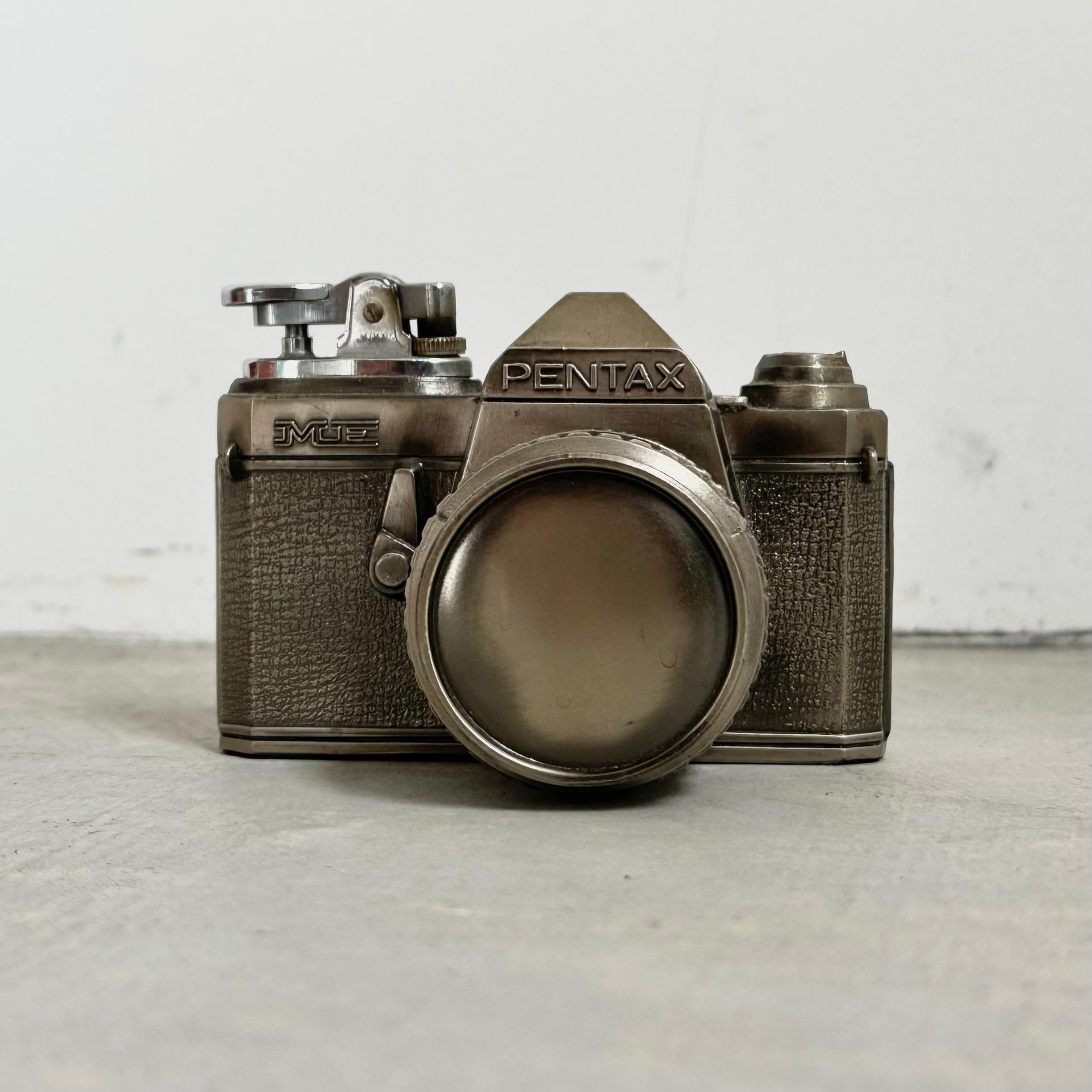 Nehmen Sie dieses unglaubliche Vintage-Feuerzeug von Pentax Camera mit nach Hause, solange es noch auf dem Markt ist. Selten und in perfekt funktionierendem Zustand. Einstellbares Feuerzeug mit einer starken Flamme.

Der Künstler hat bei diesem