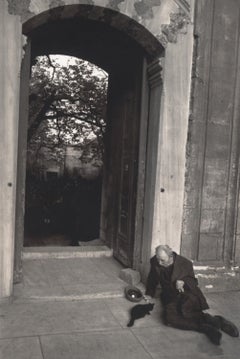 Istanbul, Turchia (Uomo appoggiato alla porta che dà da mangiare a un gatto)