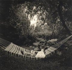 Kemio, Finland (Children laying in hammock in lush garden)