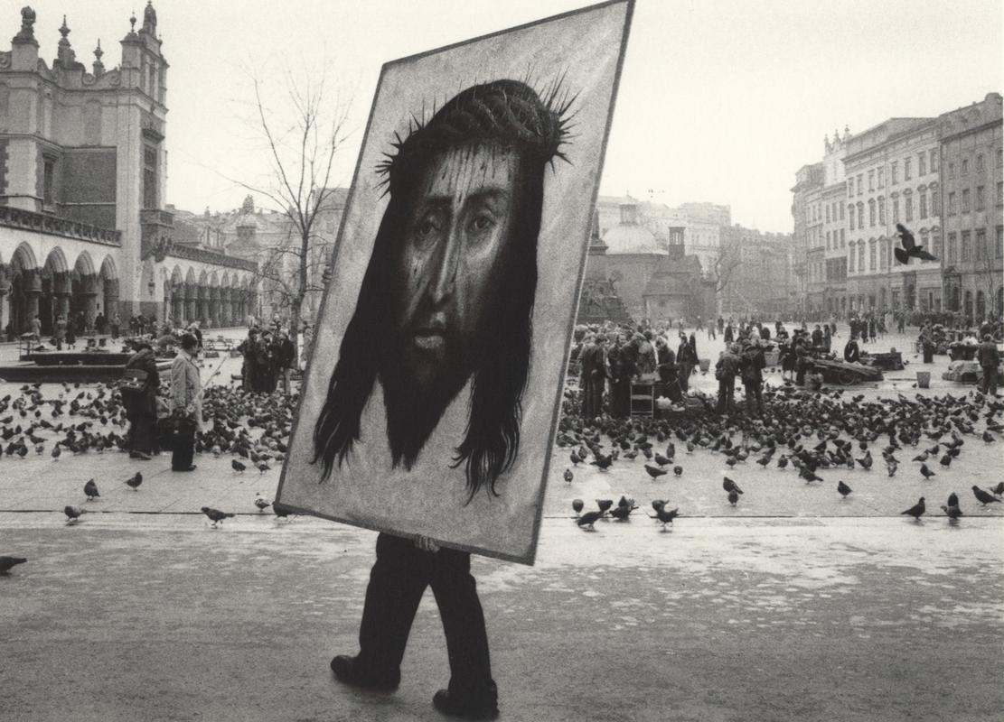 Pentti Sammallahti Black and White Photograph - Krakow, Poland (Painting of Jesus Christ moving though city square))