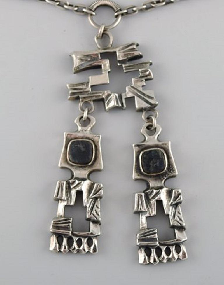 Pentti Sarpaneva, Finland. Modernist necklace in silver, 830 with matching earrings. 
Finnish design. Dated 1974.
Necklace full length: 46 cm.
Pendant measures: 8 x 4 cm.
Earrings measure: 20 x 12 mm.
Stamped.
In excellent condition.