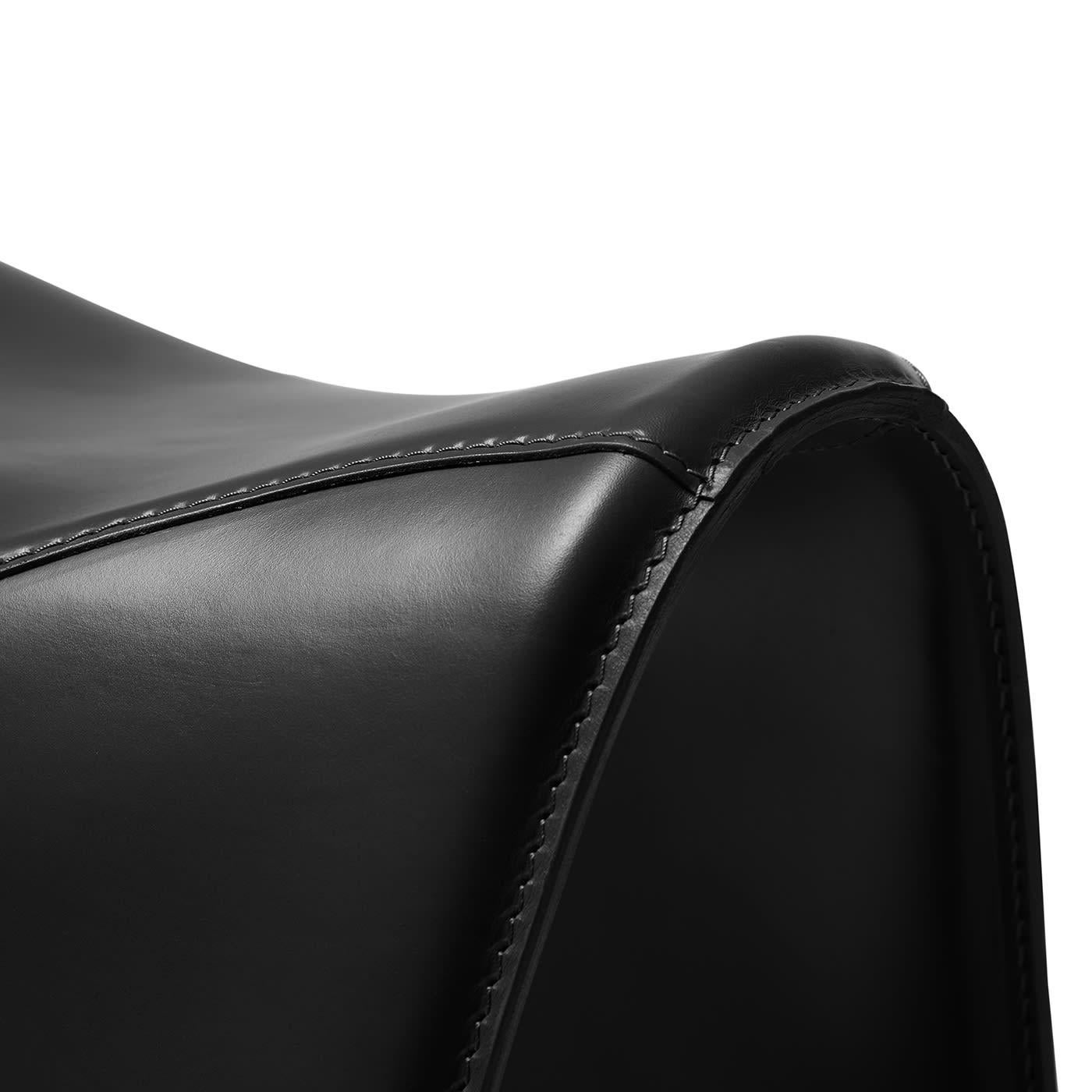 An artful take on horseback saddles, this stool was designed to provide a comfortable seating experience while playing a precious evocative function. Its sleigh structure in curved steel is luxuriously enveloped by a black cover in full-grain