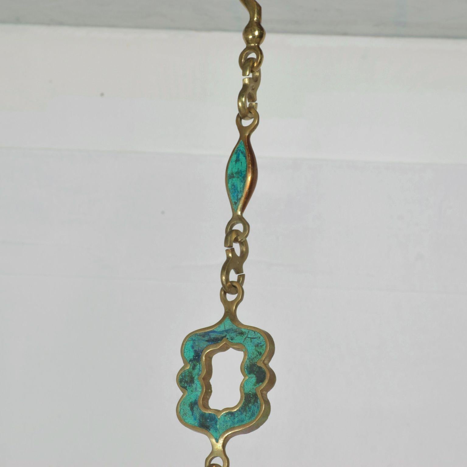 For your consideration: Fabulous Pepe Mendoza Brass and Turquoise Enamel Inlay Chain in Malachite Coloration, Mid Century Modern Mexico.

Brass Elephant with decorative hand symbol and figurine featured on hanging chain.

Dimensions: 40
