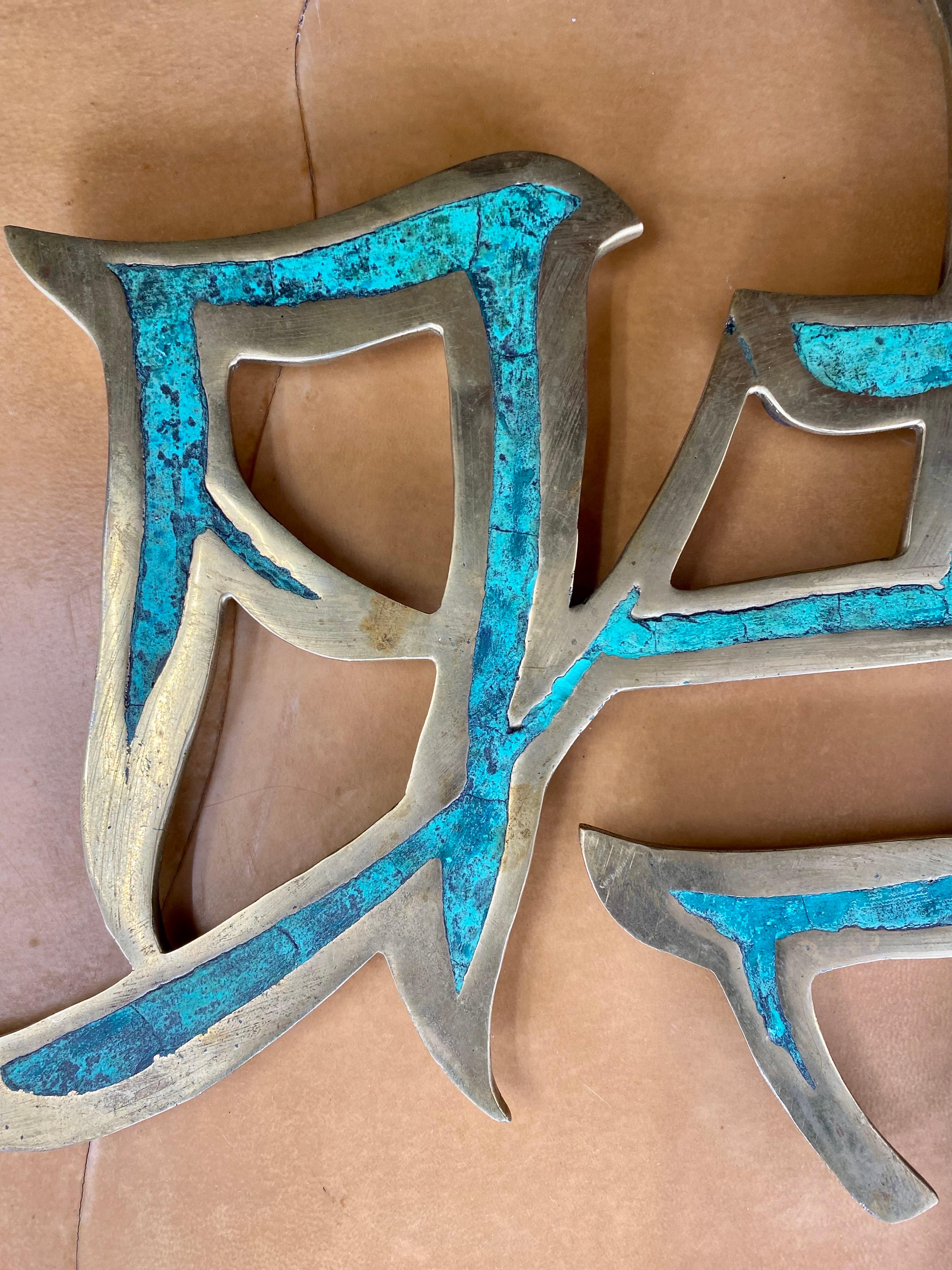 Bellissimo ornamento messicano modernista da parete in ottone con caratteri cinesi Kanji di Pepe Mendoza intarsiati con malachite e un anello in ottone sul retro per essere appeso, Messico, circa anni '60. 

Dimensioni: 14