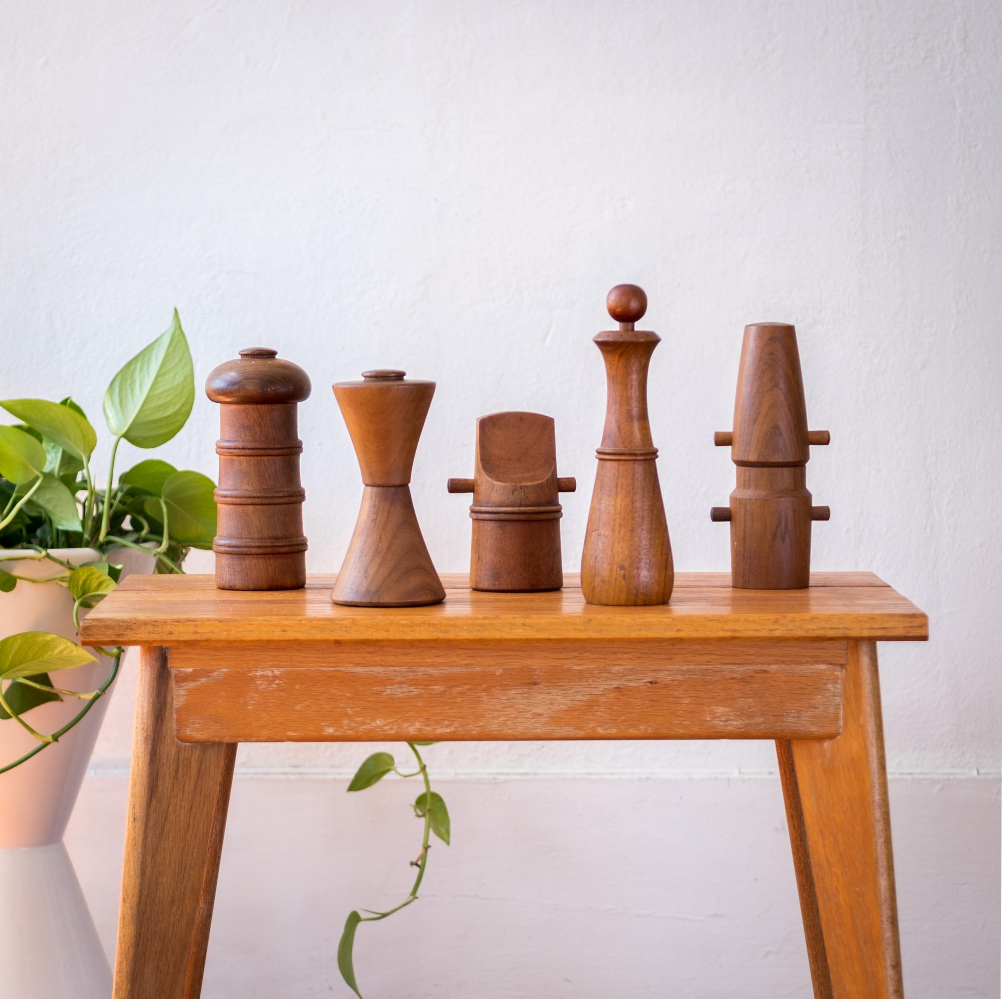 Collection of five teak pepper mills by Jens Quistgaard. Early metal grinding mechanisms produced by Peugeot. The mills were produced by Dansk in Denmark, circa 1950s. 

  