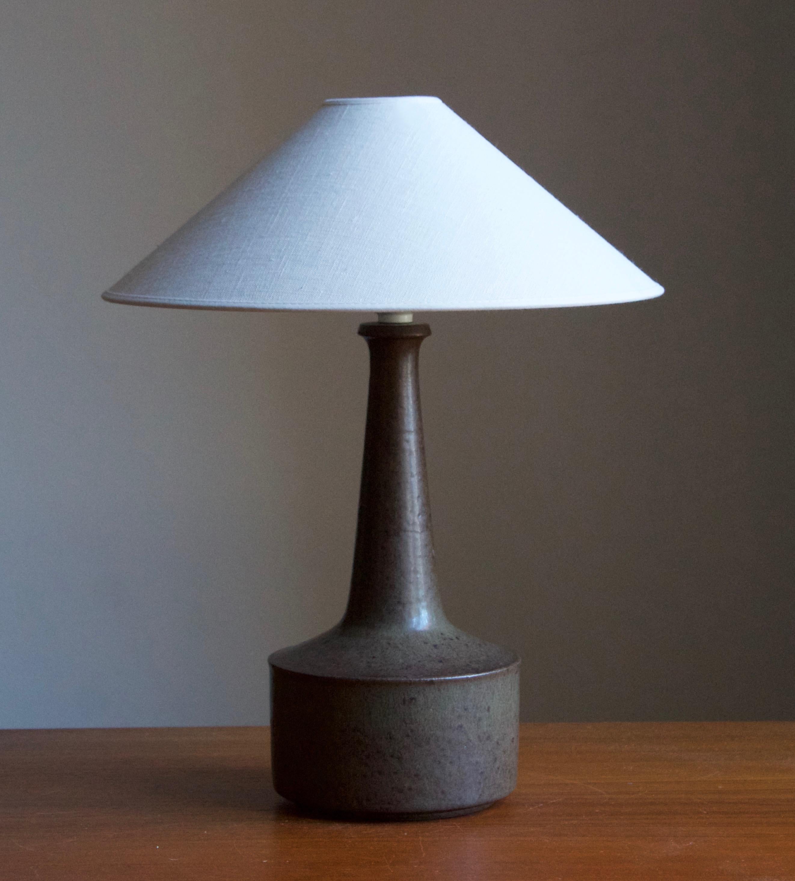 A table / desk lamp designed by husband and wife Per & Annelise Linneman-Schmidt. Handcast in stoneware, green glaze. Produced in their own Studio, named Palshus, in Sengeløse, Denmark. Signed.

Sold without lampshade. Stated dimensions exclude