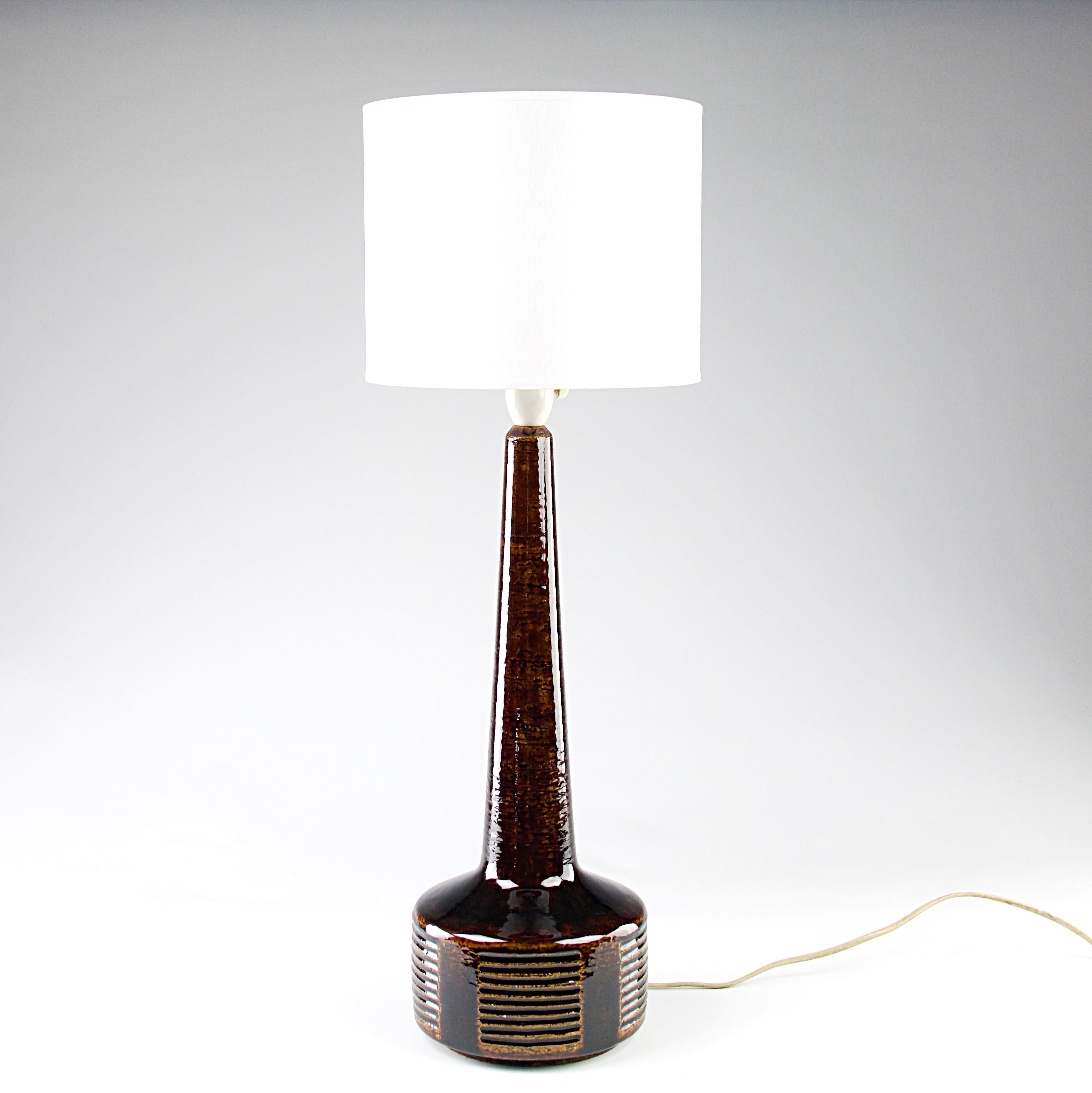 Belle lampe scandinave par Per et Annelise Linnemann Schmidt pour Palshus, Danemark circa 1960. Décorations émaillées en chamotte avec bande horizontale, glaçure brun-orange.

En parfait état. Abat-jour non inclus.

Dimensions en cm du corps en