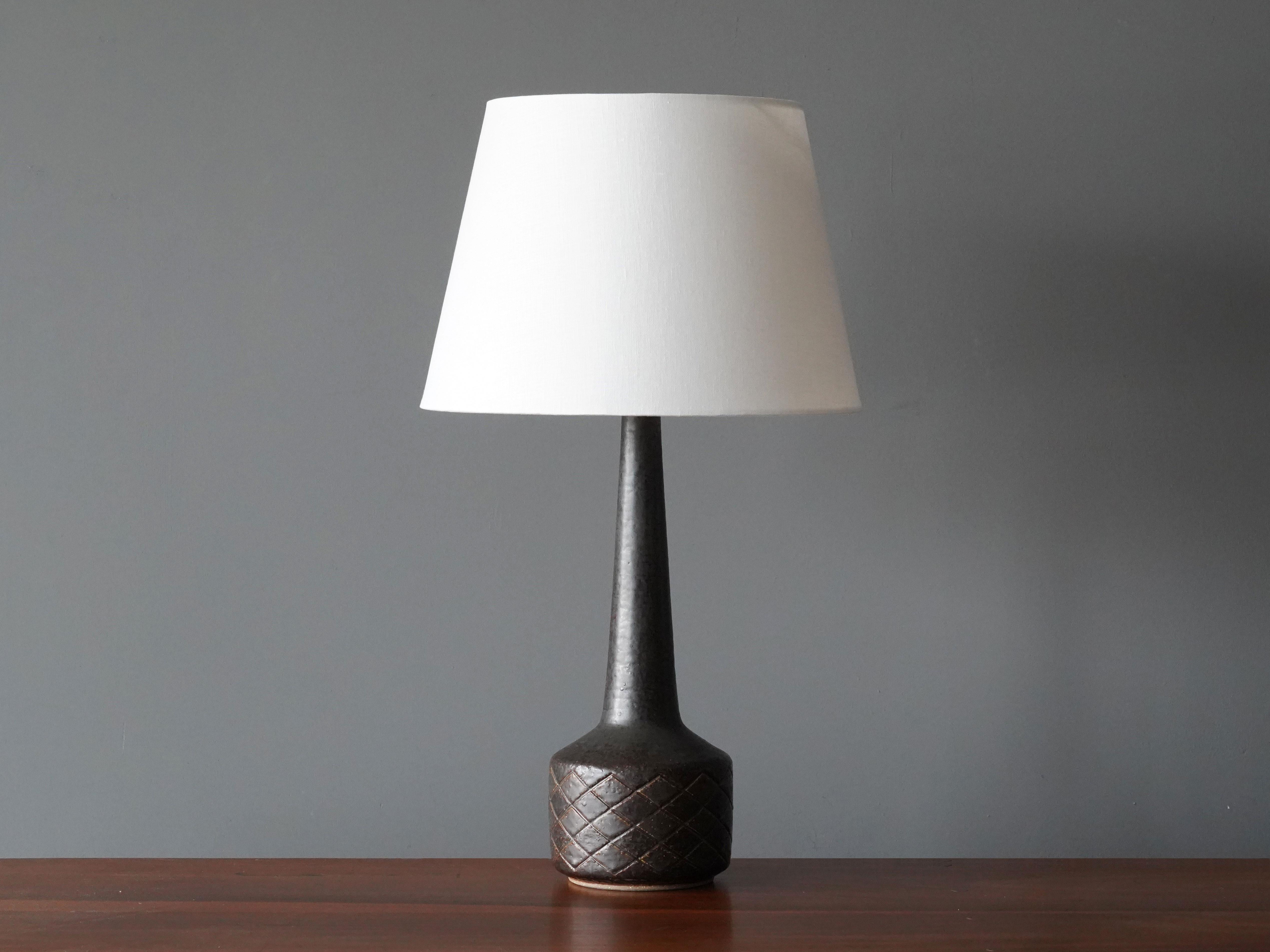 A table / desk lamp designed by husband and wife Per & Annelise Linneman-Schmidt. Handcast in firesand, each lamp with a unique glaze. Produced in their own Studio, named Palshus, in Sengeløse, Denmark. Signed

This lamp of early production,