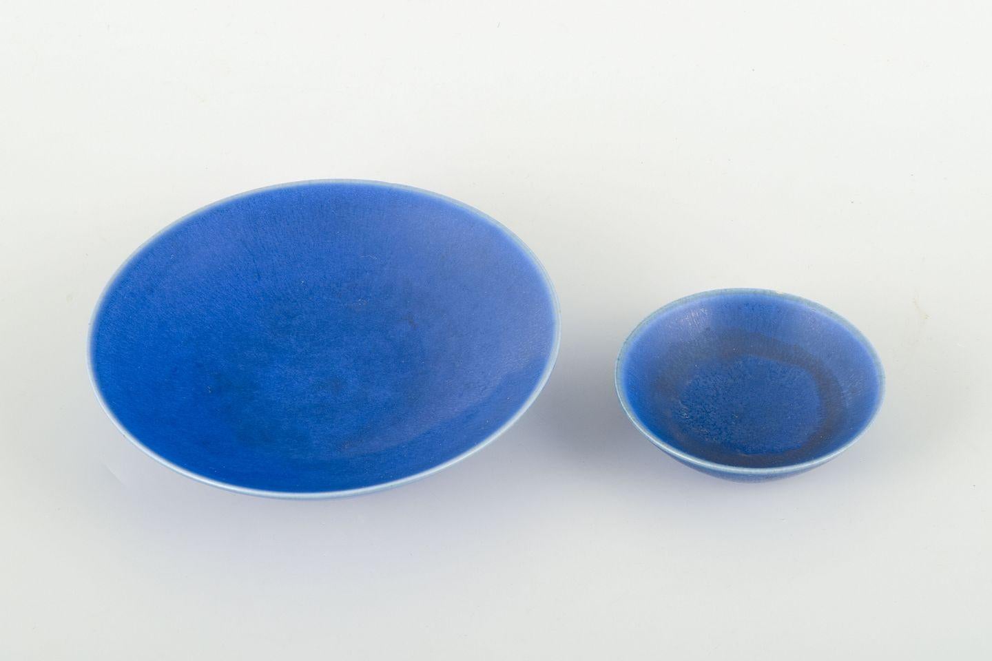 Per Linnemann-Schmidt para Palshus.
Dos cuencos de gres con un vidriado azul intenso y vibrante, con vivas variaciones en la superficie. Su forma sencilla y refinada permite que el esmalte despliegue su profundidad, pasando de mate a brillante a