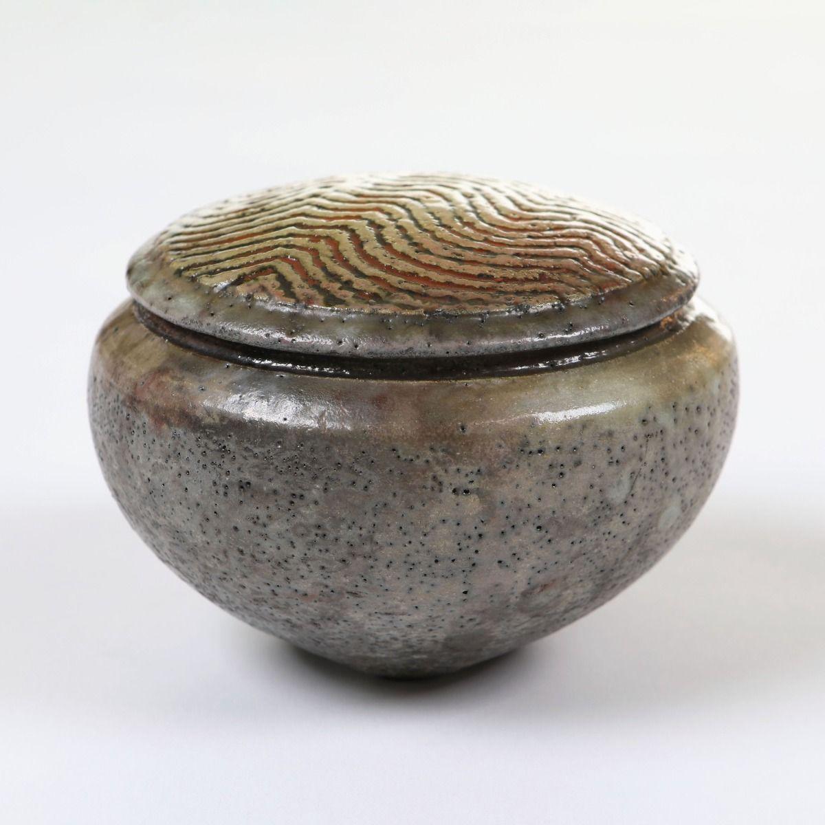 Una bellissima bomboniera in gres creata dal famoso ceramista danese Per Weiss.
Il coperchio è ornato da un motivo organico a onde, caratteristico dello stile di Weiss, che conferisce consistenza e fascino artistico.
L'esterno è smaltato nei toni