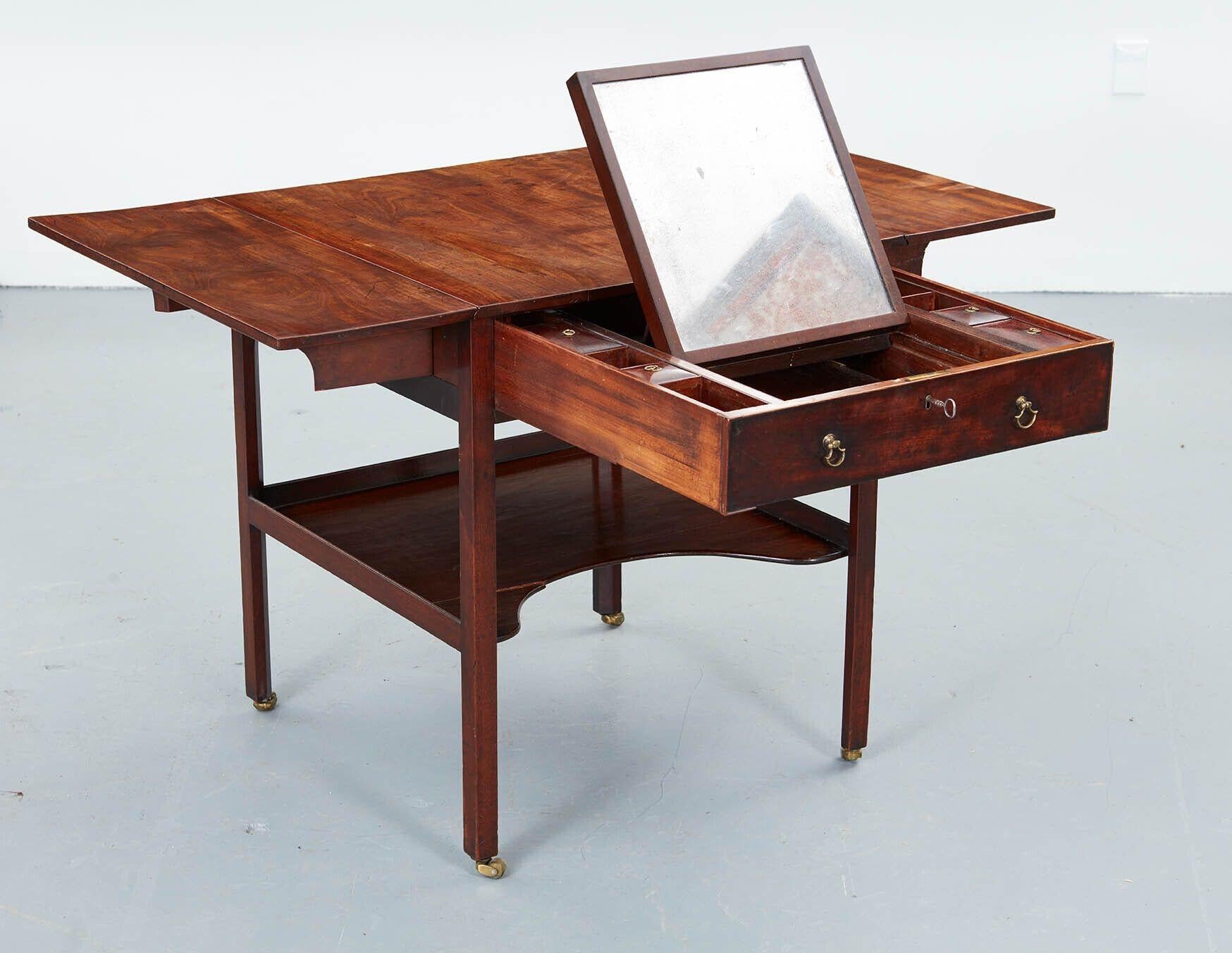 Exceedingly fine George III gentleman's dressing table/Pembroke table attributed to Thomas Chippendale, the richly figured mahogany top with drop leaves, over fully fitted drawer with lidded compartments and having a pull-out dressing mirror,