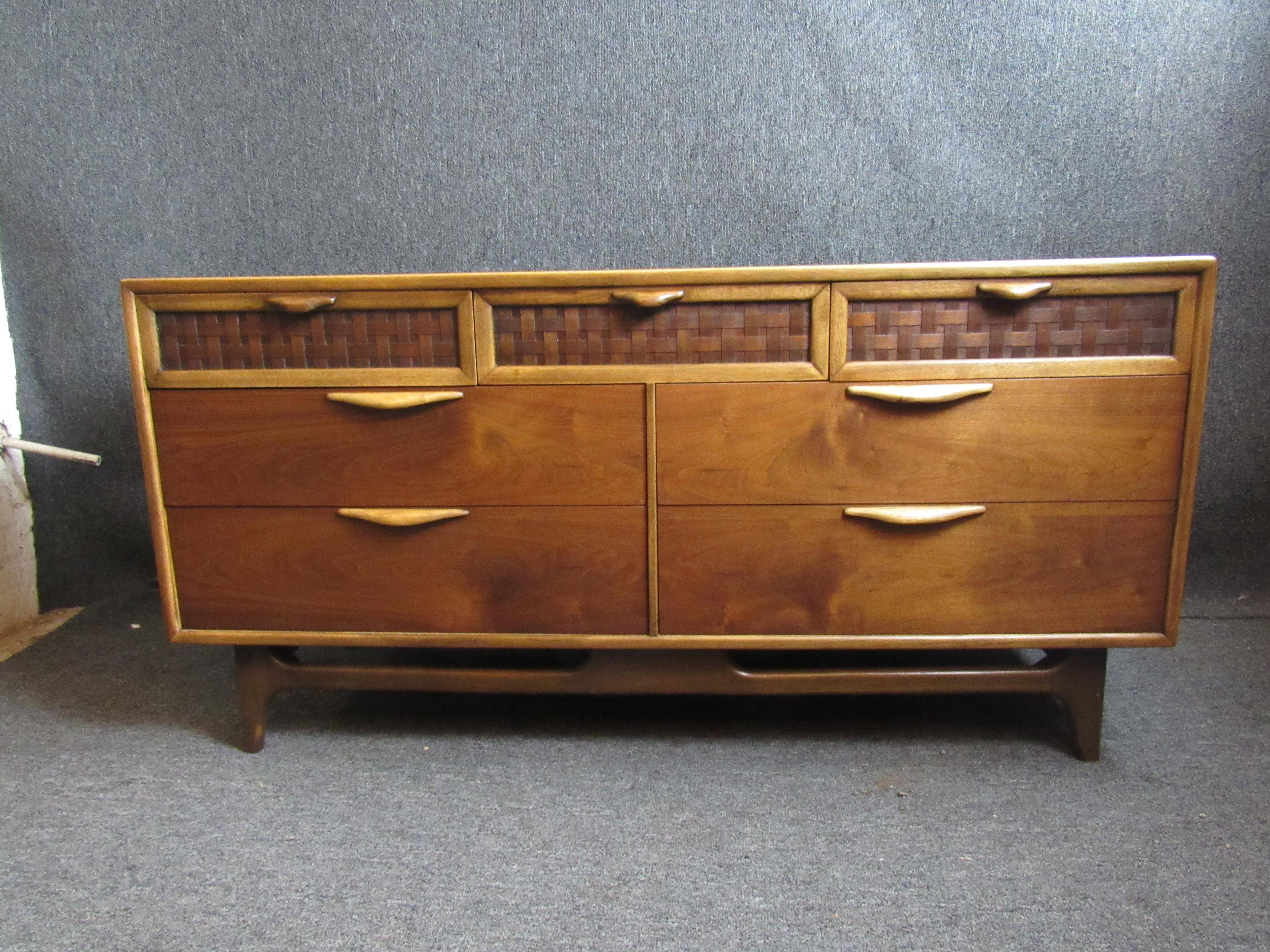 Gorgeous mid-century walnut credenza made by the Lane Furniture Company. Beautiful natural wood grains come together with unique lattice accents on the drawers for a piece that is sure to be the highlight of any room in the home or office. Seven