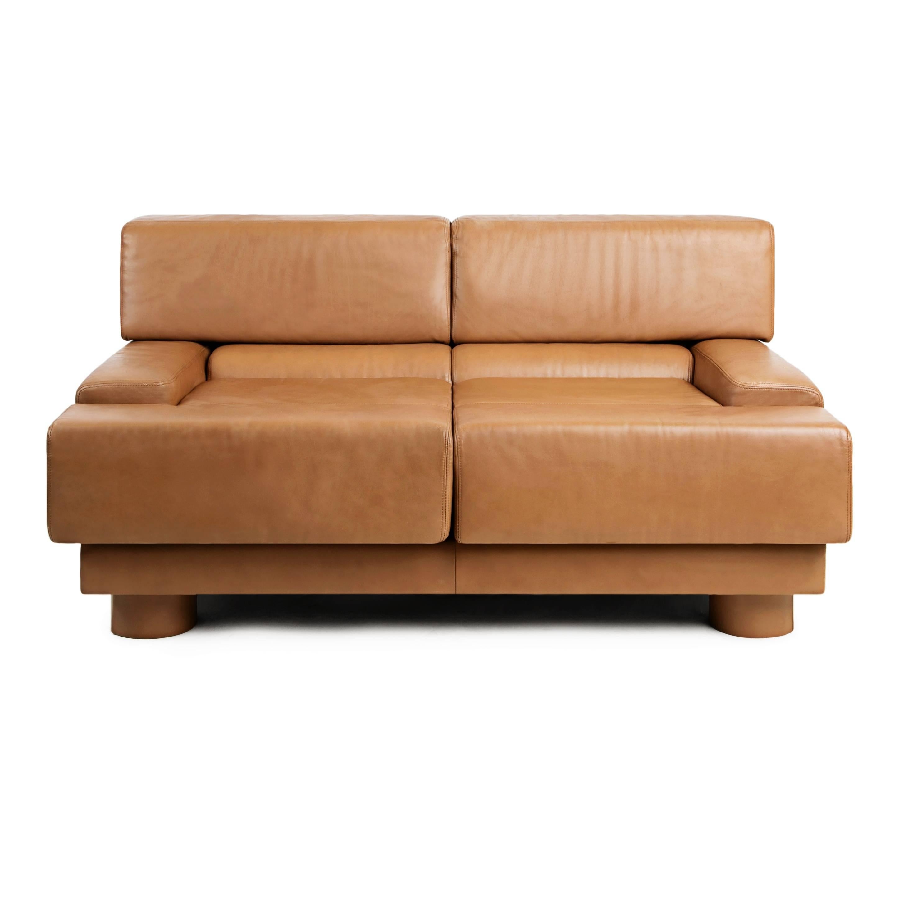 An impressive pair of tan leather loveseats by Brazilian designer Percival Lafer, both retain original labels underneath. These sizable sofas provide a deep comfortable seat, with a broad backrest and low flat arms - perfect for balancing a drink