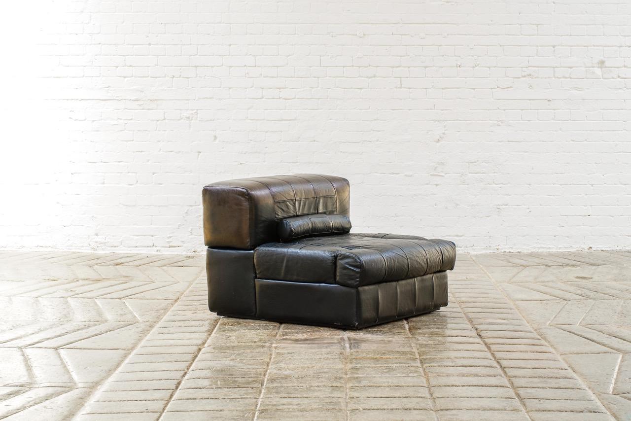 A modular black leather sofa with innovative articulated arms ( can be up or down into the unit) the back lifts off to reveal some storage. Amazing as a pairs of chairs, or two smaller sofas.

These four pieces can be arranged as two pairs single