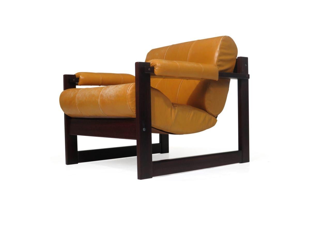 Pair of mid-century Brazilian Mahogany lounge chairs and ottoman designed by Percival Lafer, circa 1970 Brazil. The chairs are crafted of solid Brazilian Mahogany upholstered in a the original tan leather with tufting, upholstered armrests and sling