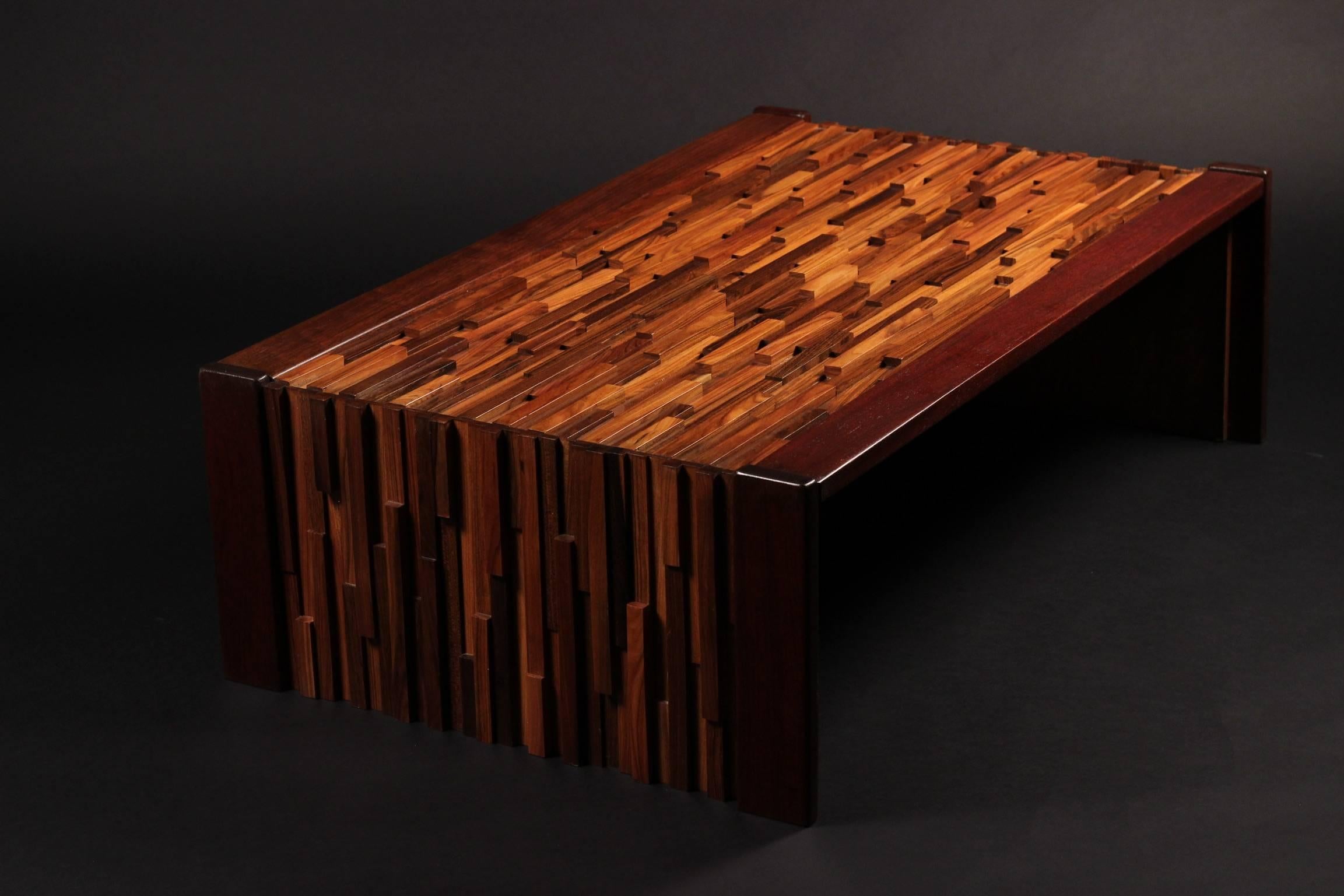 A Brazilian coffee or cocktail table with a wonderful sculptural quality. A relief of various tropical hardwoods in different heights and lengths to create a Brutalist effect, edged with Mahogany and fitted glass top. A table that comes to life when