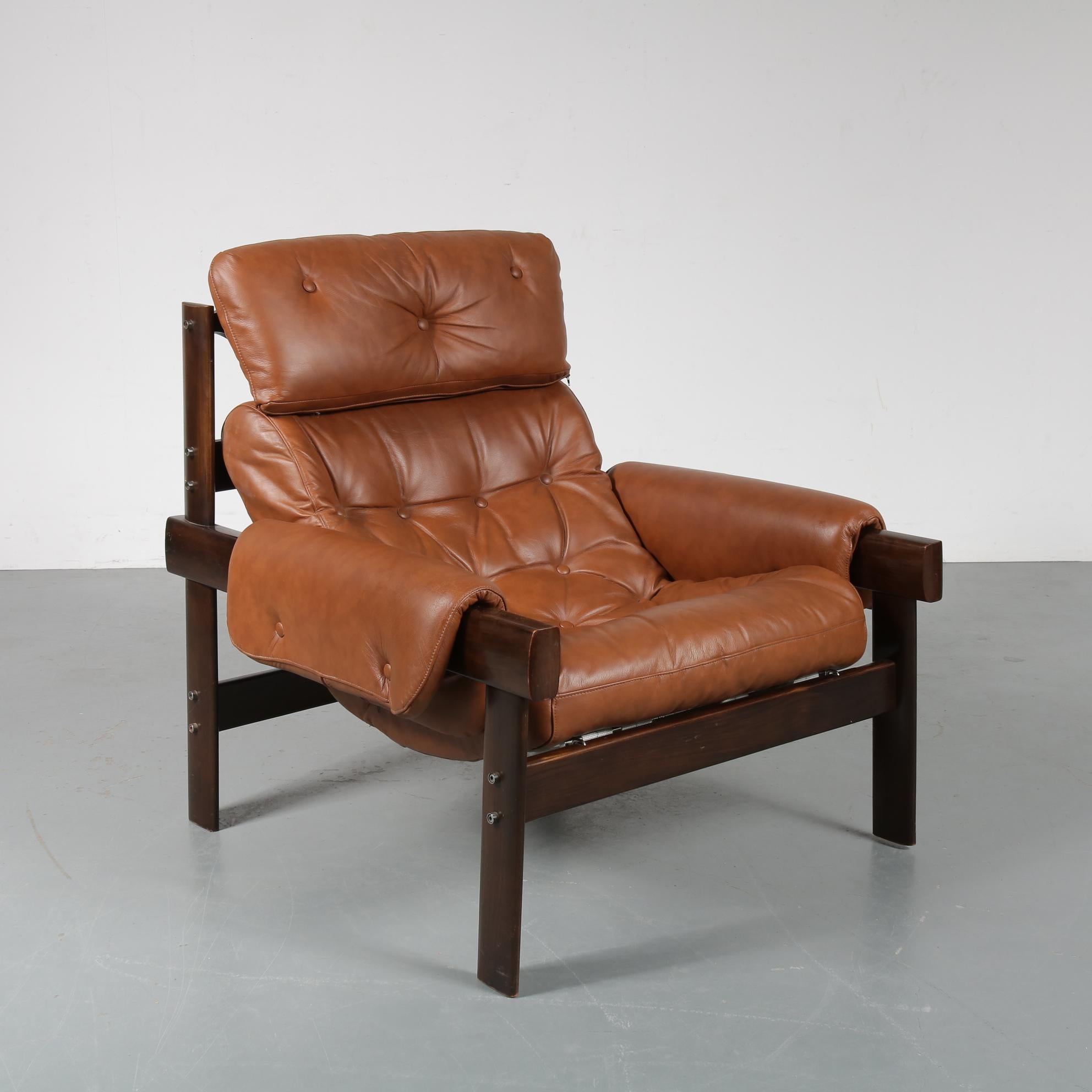 A wonderful lounge chair designed by Percival Lafer, made in Brazil in the 1970s.

This beautiful piece is made of high quality, deep brown Brazilian hardwood. The comfortable seat is upholstered in high quality cognac leather, all together a