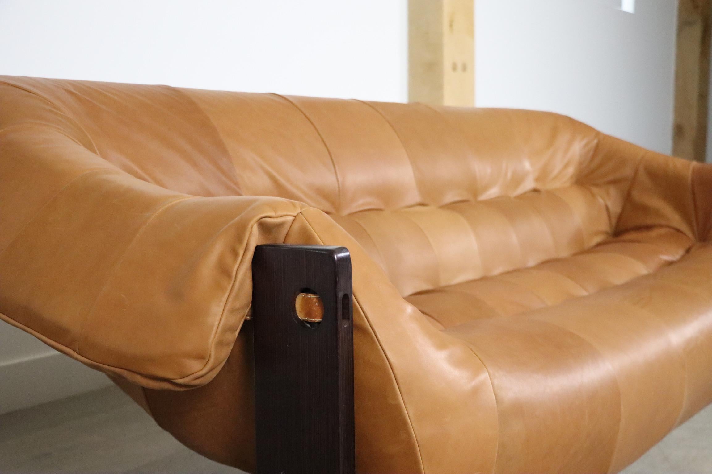 Incroyable canapé trois places en cuir cognac de Percival Lafer, modèle MP-97. 
Ce magnifique canapé est composé d'un cadre en bois dur brésilien avec des sangles en cuir de selle et un coussin en cuir cognac. Le coussin d'assise est retapissé dans