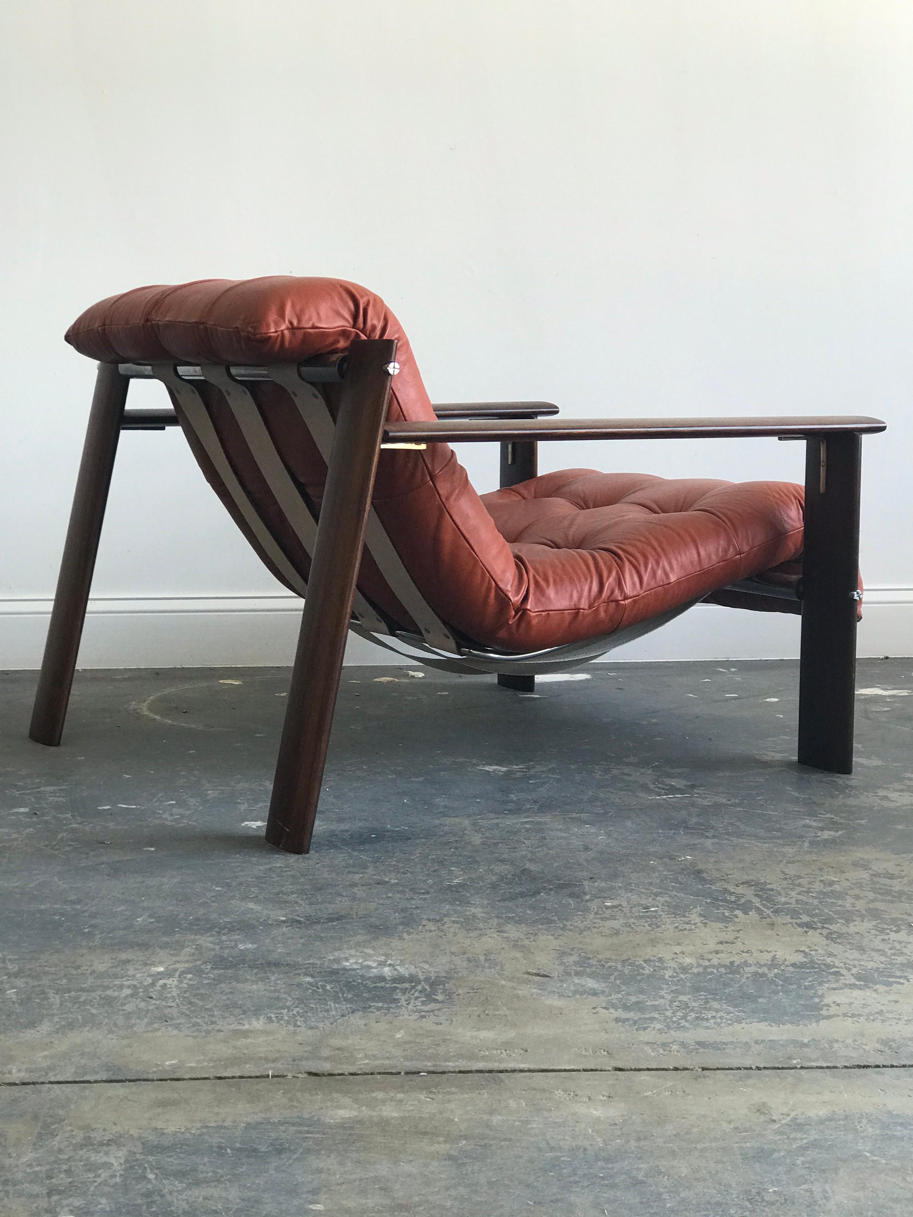 Stunning lounge chair designed by Percival Lafer in wonderful all original condition. Features a wood and nickel frame with a slung orange leather seat. Leather is in wonderful condition as is the frame with one very minor wear to the bottom of the