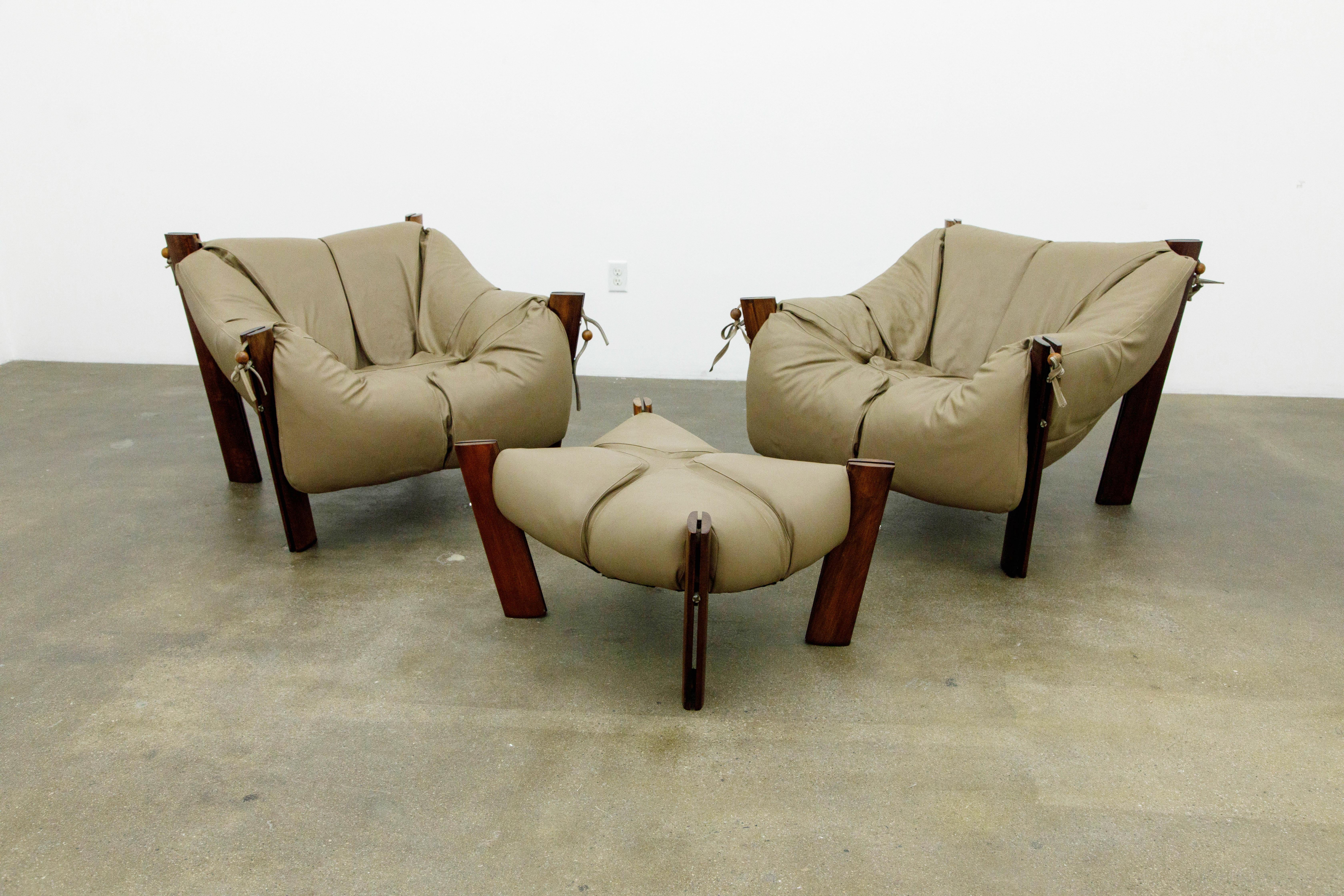 An impressive set of Percival Lafer 'MP-211' lounge chairs (2) and ottoman (1) with original labels, circa 1960s Brazil. The overstuffed lounge chairs are fashioned with leatherette ties secured with rosewood beads. This model is regarded for its