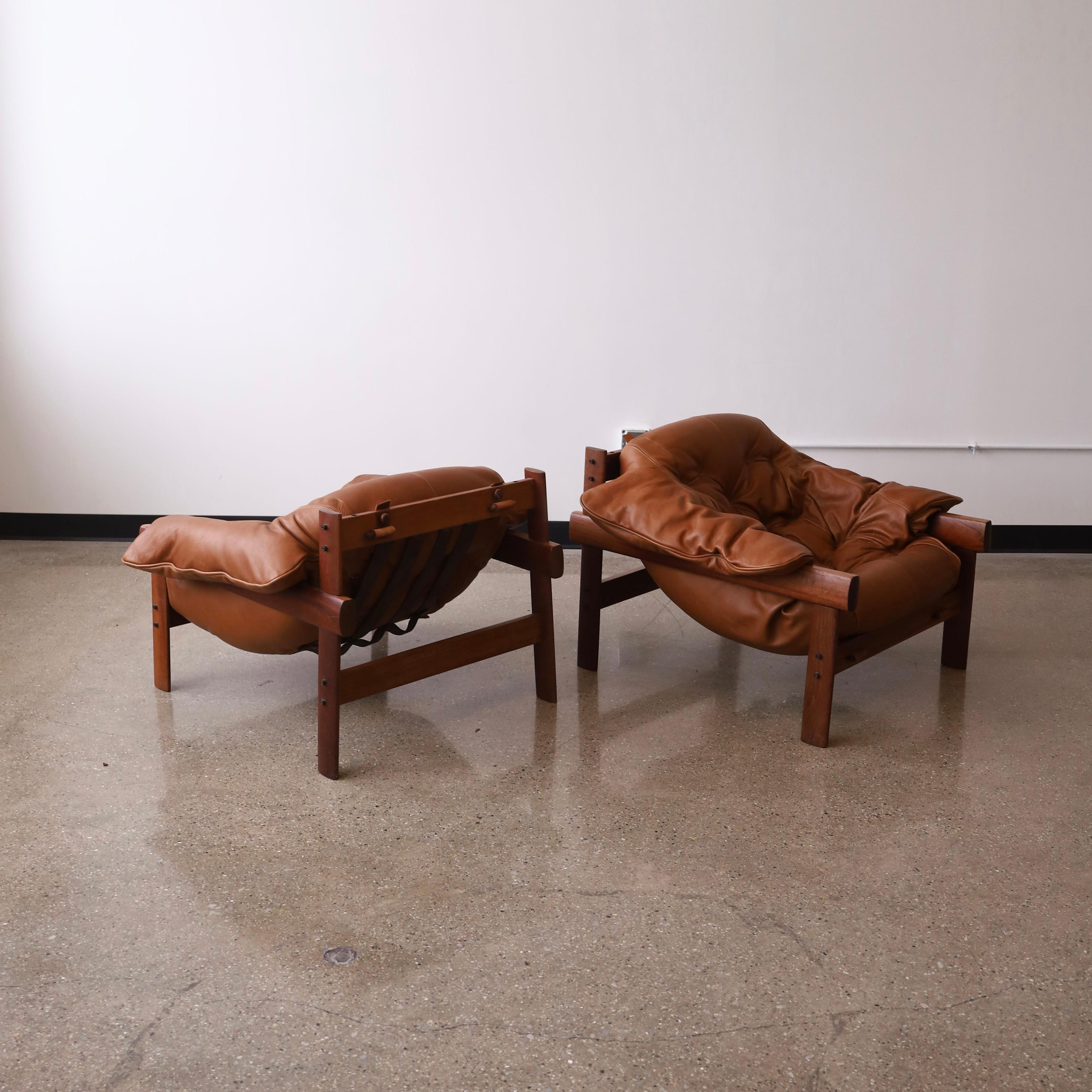 c. 1960s featuring restored cushions and new leather on the original hardwood frames. They are incredibly comfortable and will easily last another lifetime. The frames are in their original condition and have flaws consistent with age and use along