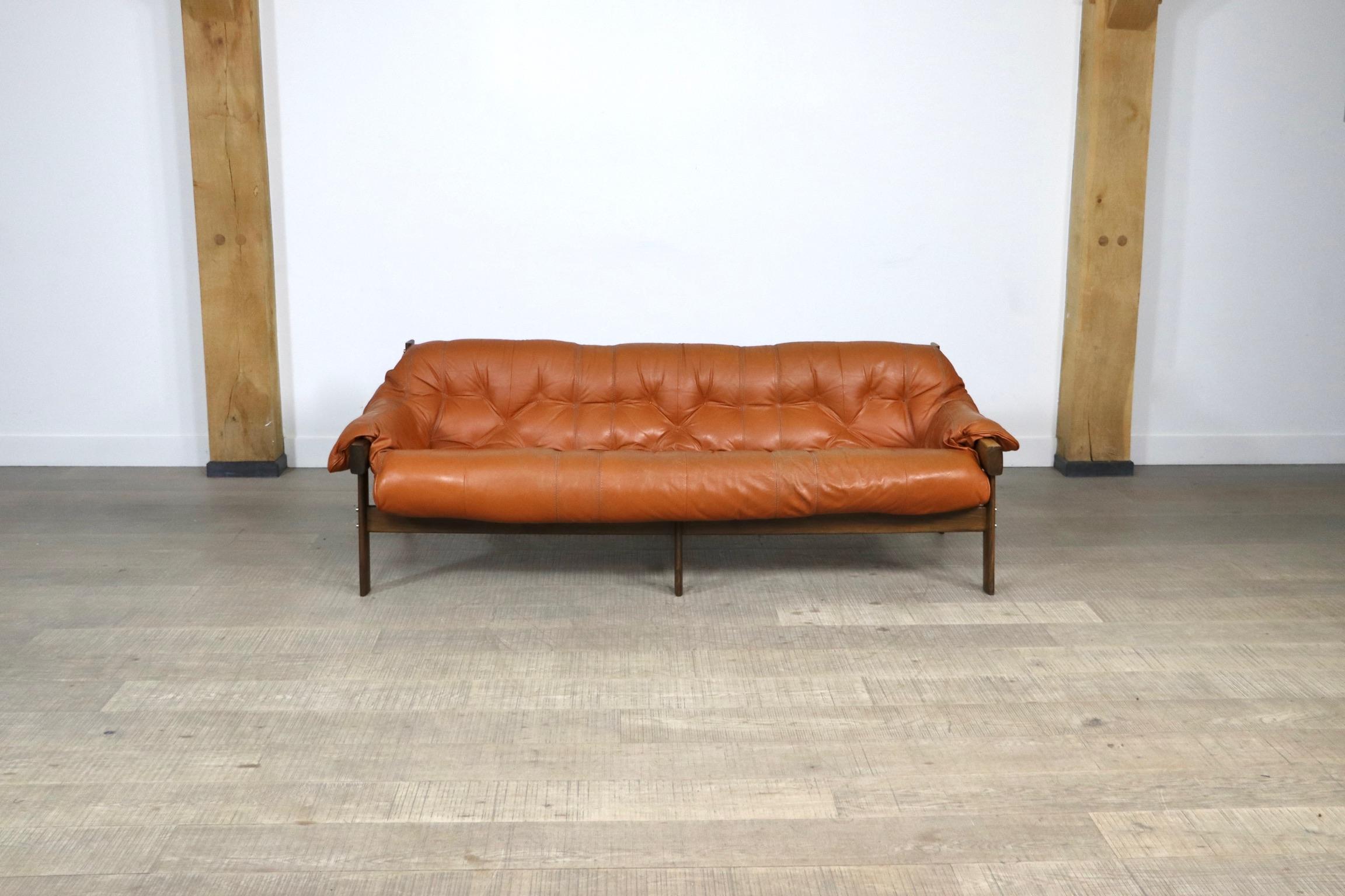Amazing MP-41 three seater sofa in original cognac leather and jacaranda wood frame, designed by Percival Lafer for MP Lafer, 1970s. The sofa has its original mark in the leather strap on the back, as shown in te pictures.
This highly comfortable