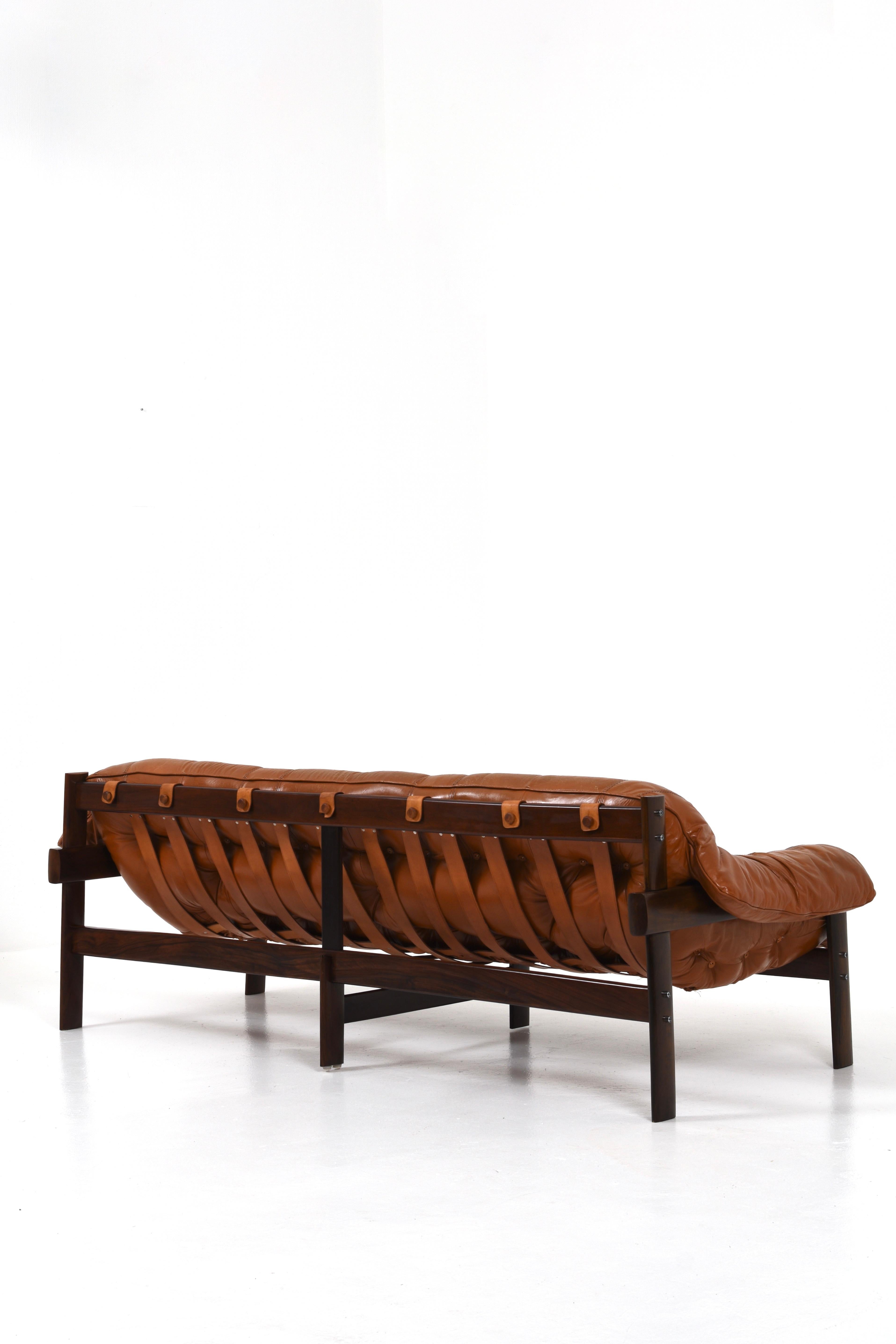 Fantastic MP-41 three-seater sofa in original cognac leather and dark solid wood frame. Designed by Percival Lafer for MP Lafer in the 70s.

The sofa has its original mark in the leather strap on the back, as shown in the picture. This very