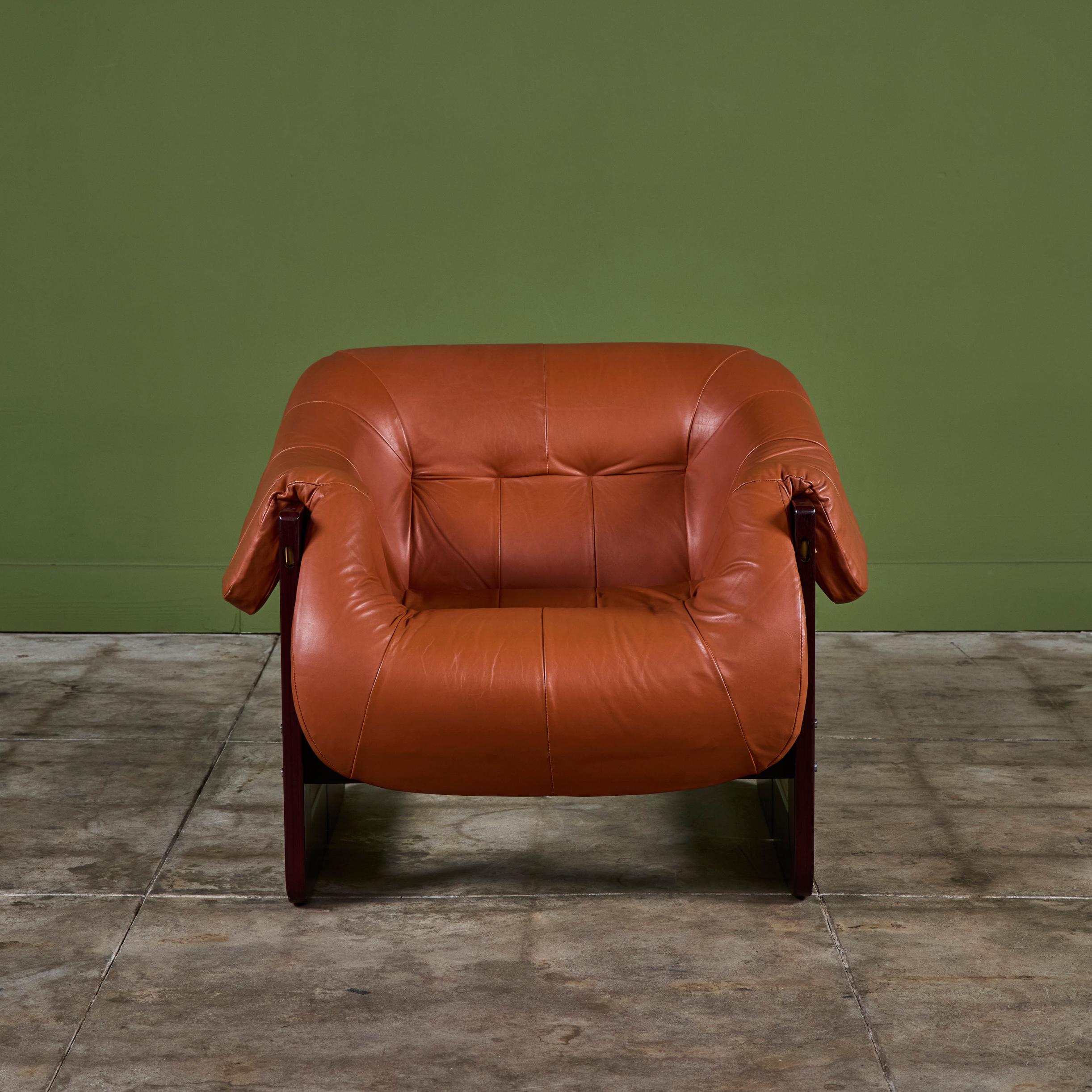 Leather lounge chair by Percival Lafer c.1960's, Brazil. The chair features the original cognac leather with a beautiful Brazilian hardwood frame. The back of the lounge chair showcases leather strapping while the seat has gorgeous tufting