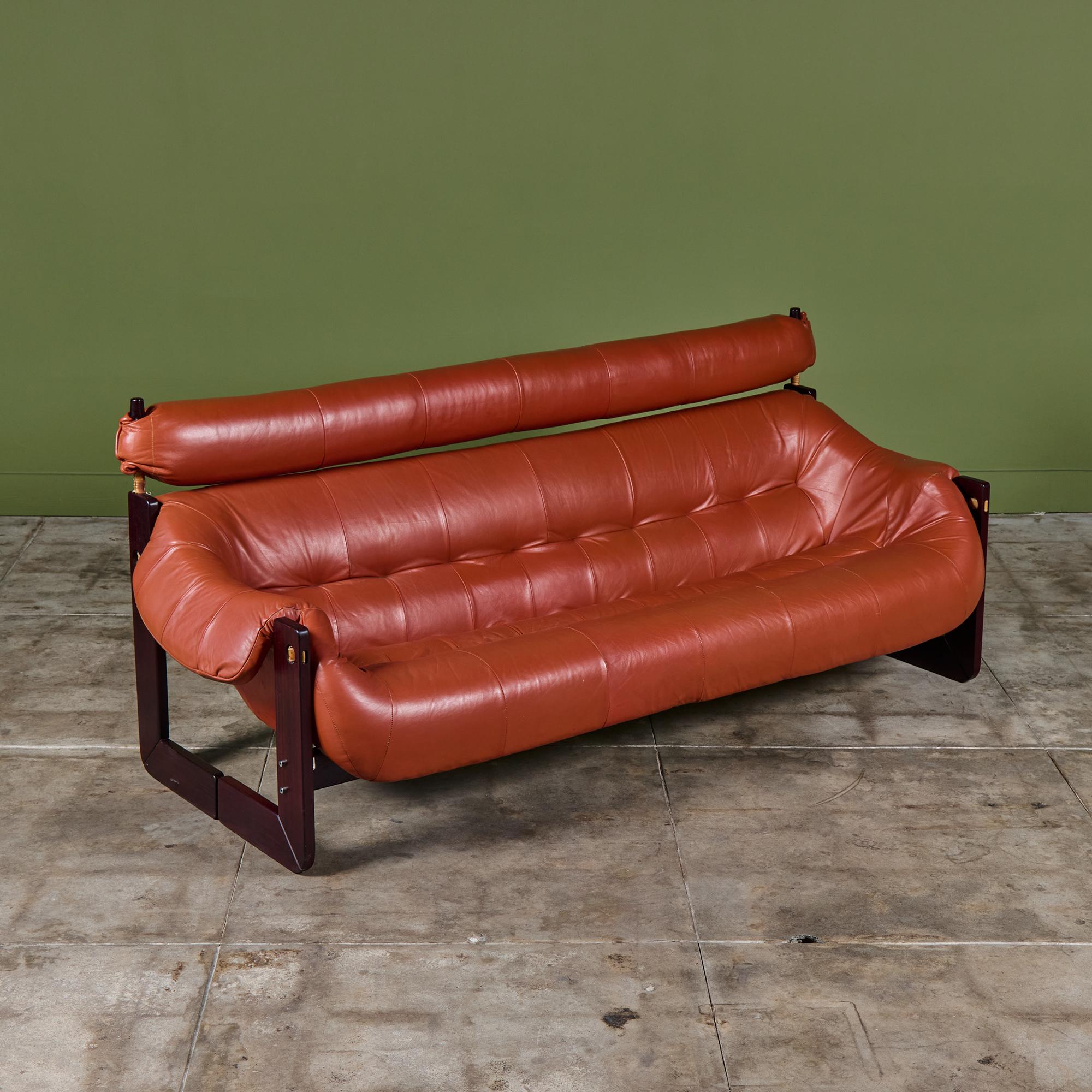 Leather sofa by Percival Lafer c.1960's, Brazil. The sofa features the original burnt rust leather with a beautiful Brazilian hardwood frame. The top of the seat back has an extended headrest that stretches the length of the sofa. The back of the