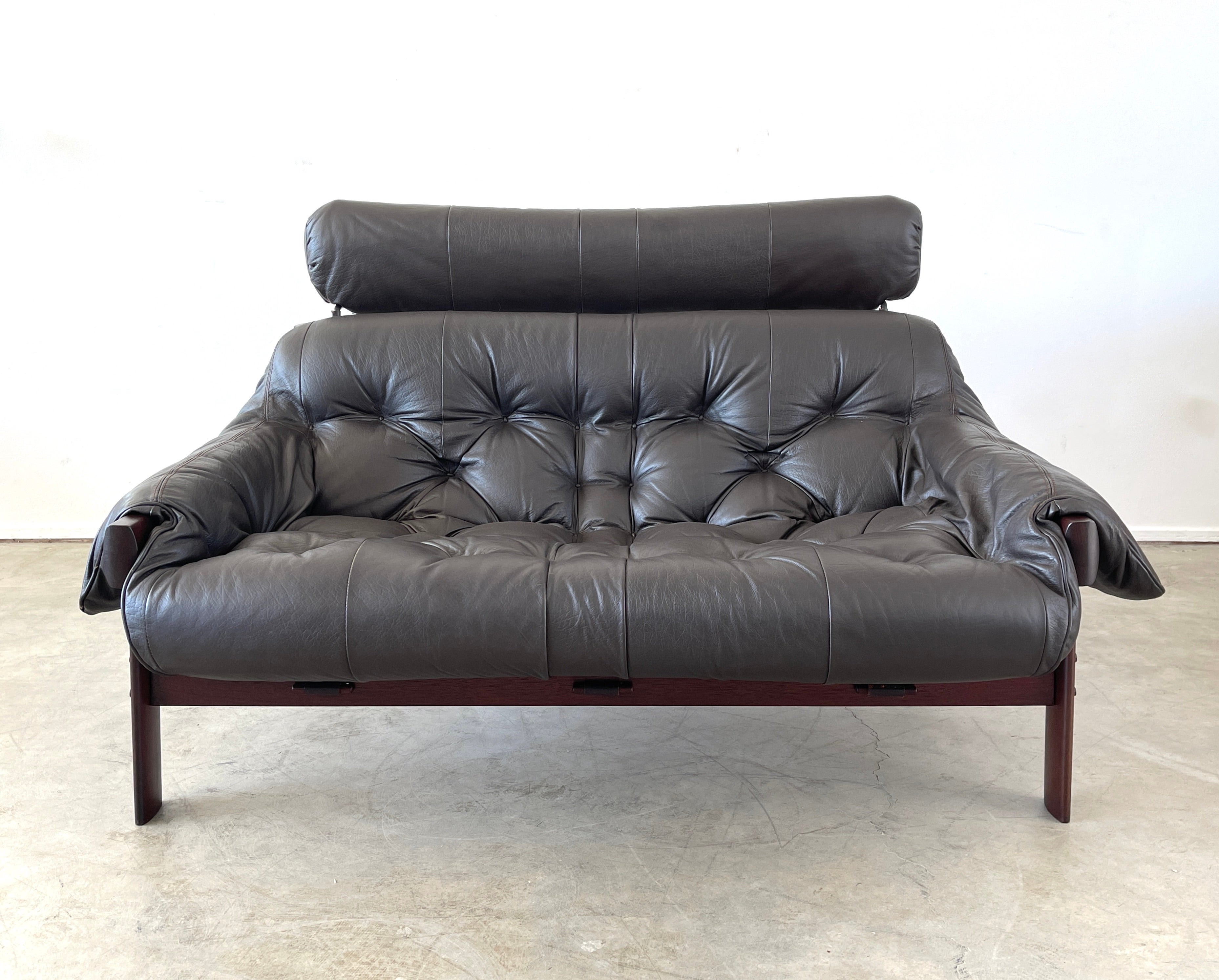 Settee by Percival Lafer with rosewood frame and black leather.
Signature sling shape with headrest and straps.
Matching sofa and chairs available. 

